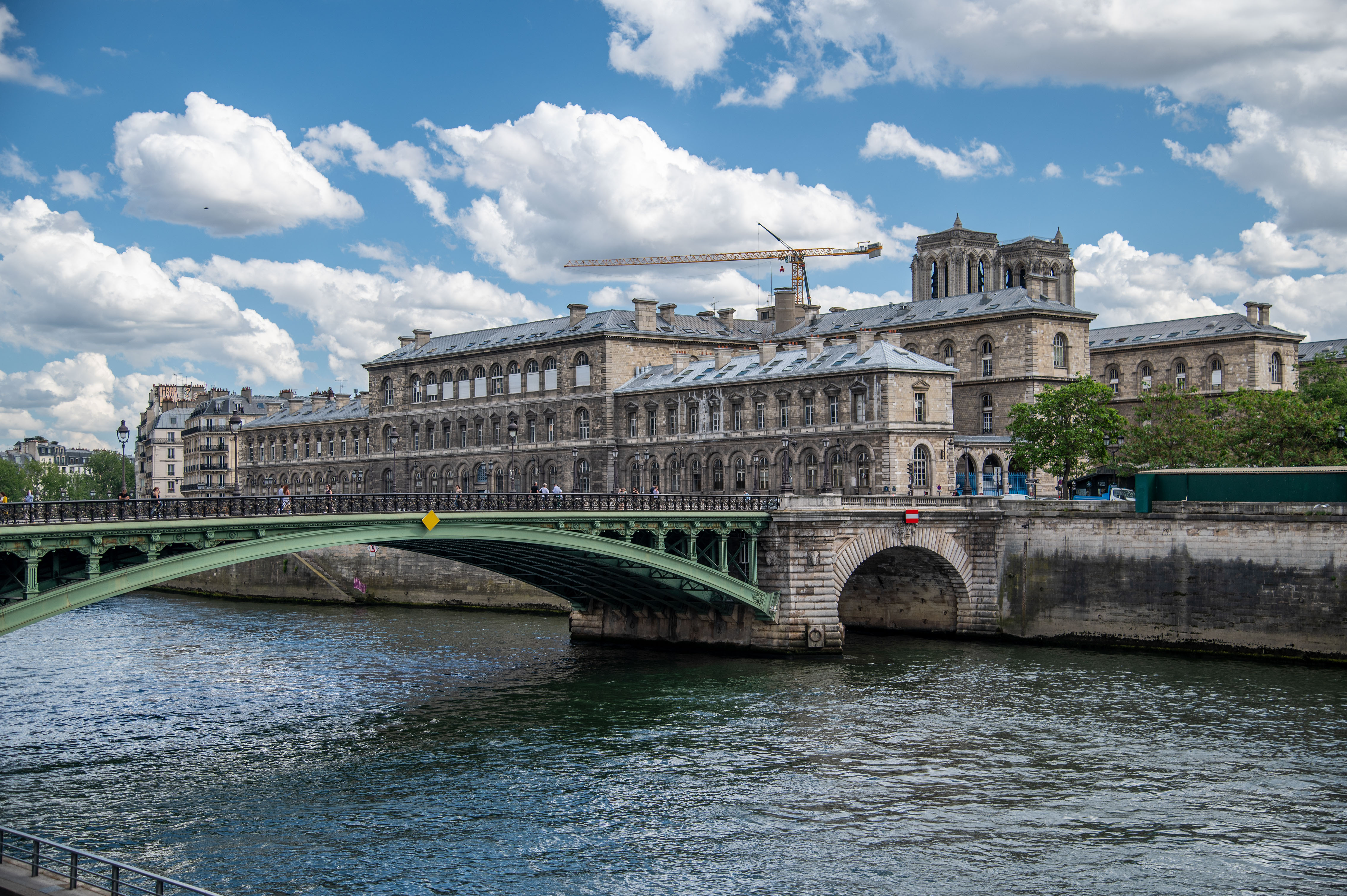 the image depicts a large, historic building along a river