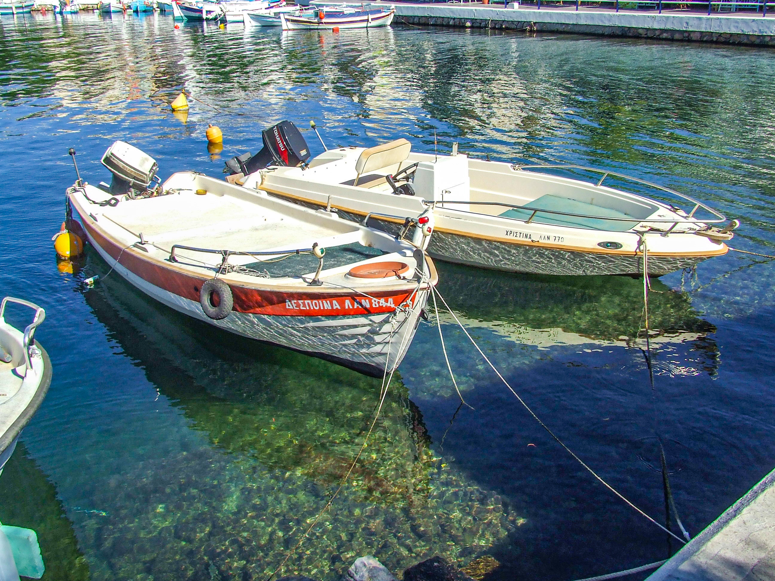 two small boats docked in a harbor