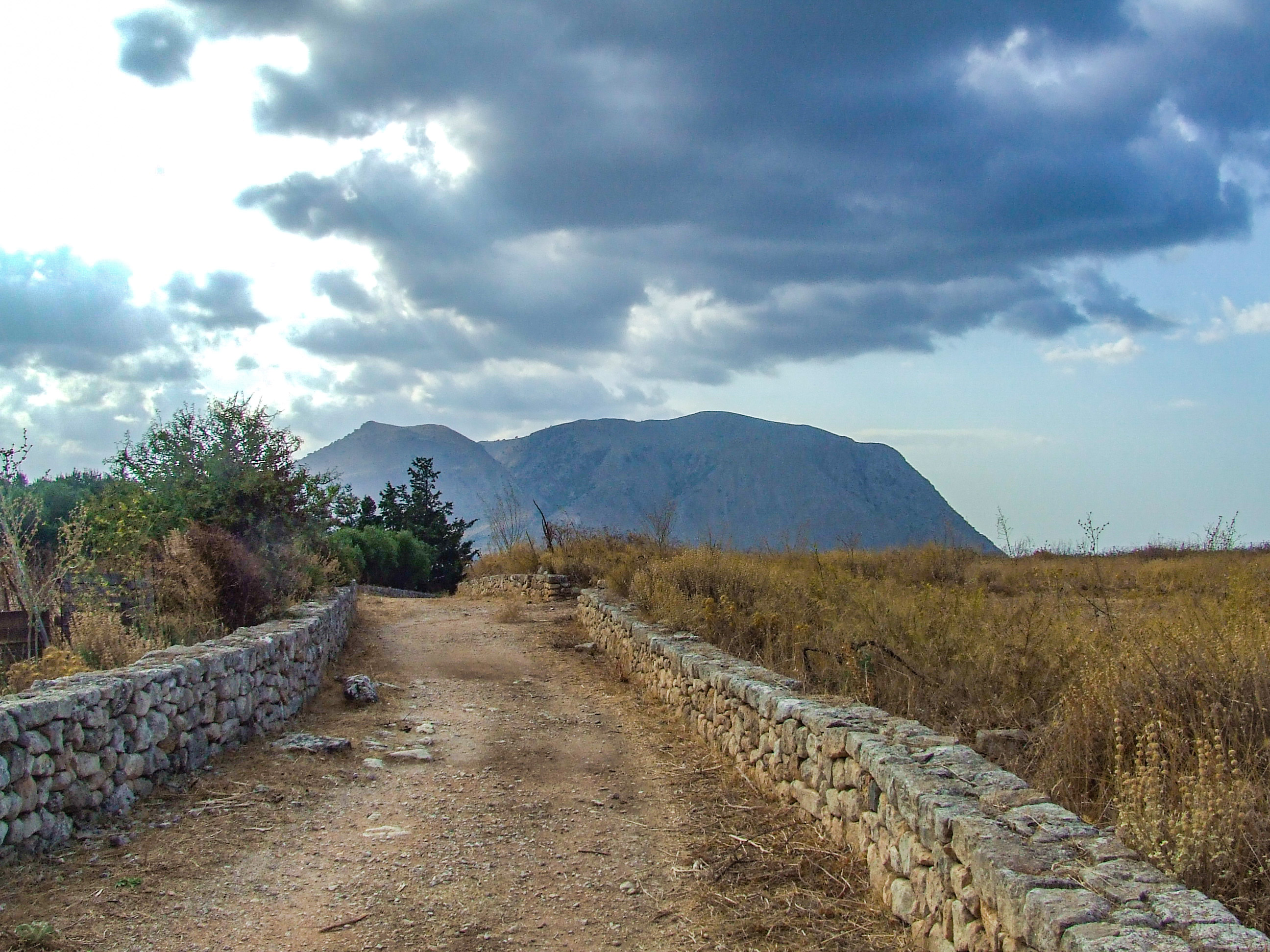 dirt path bordered by low stone walls