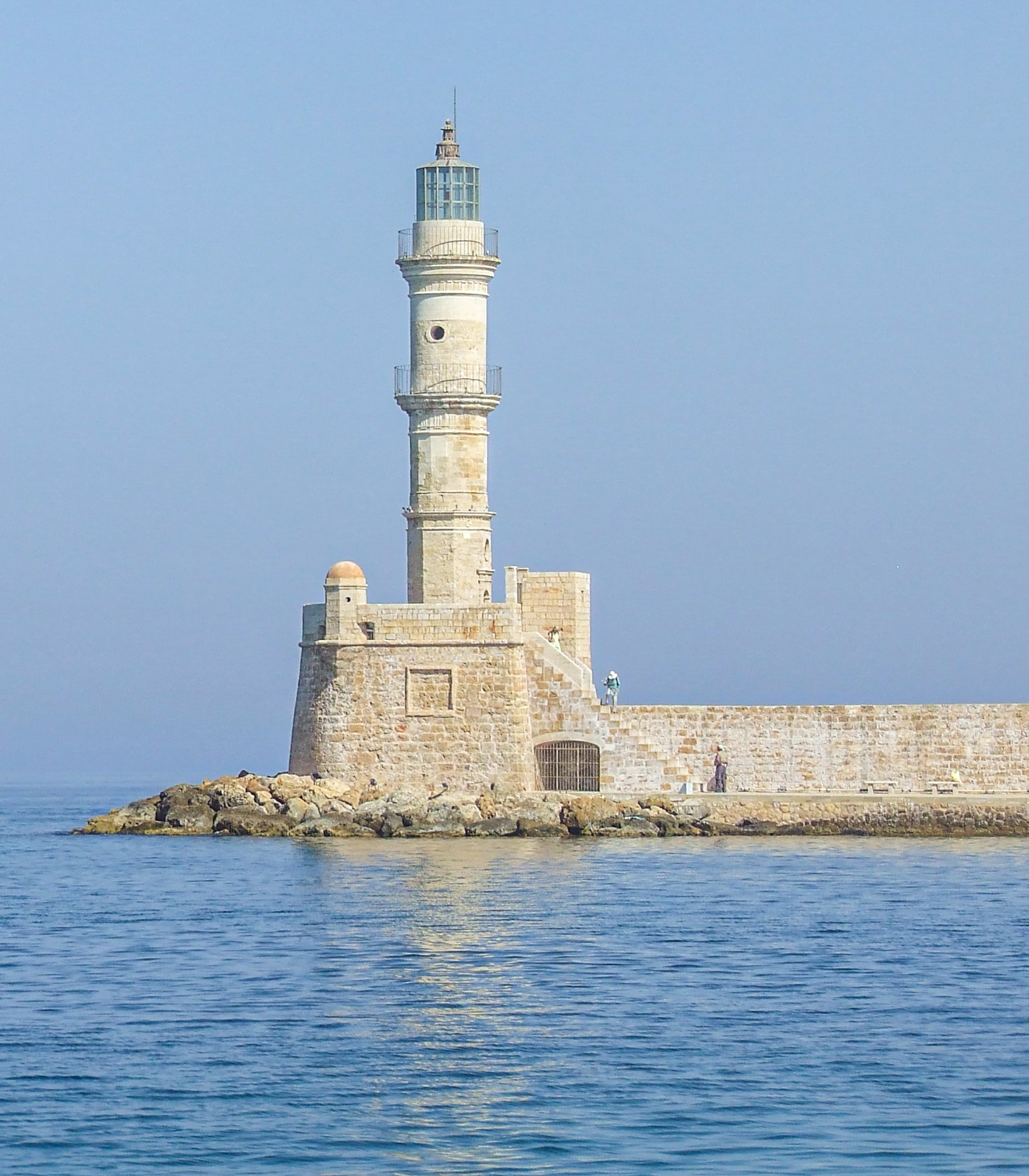lighthouse situated on a rocky outcrop extending into the sea