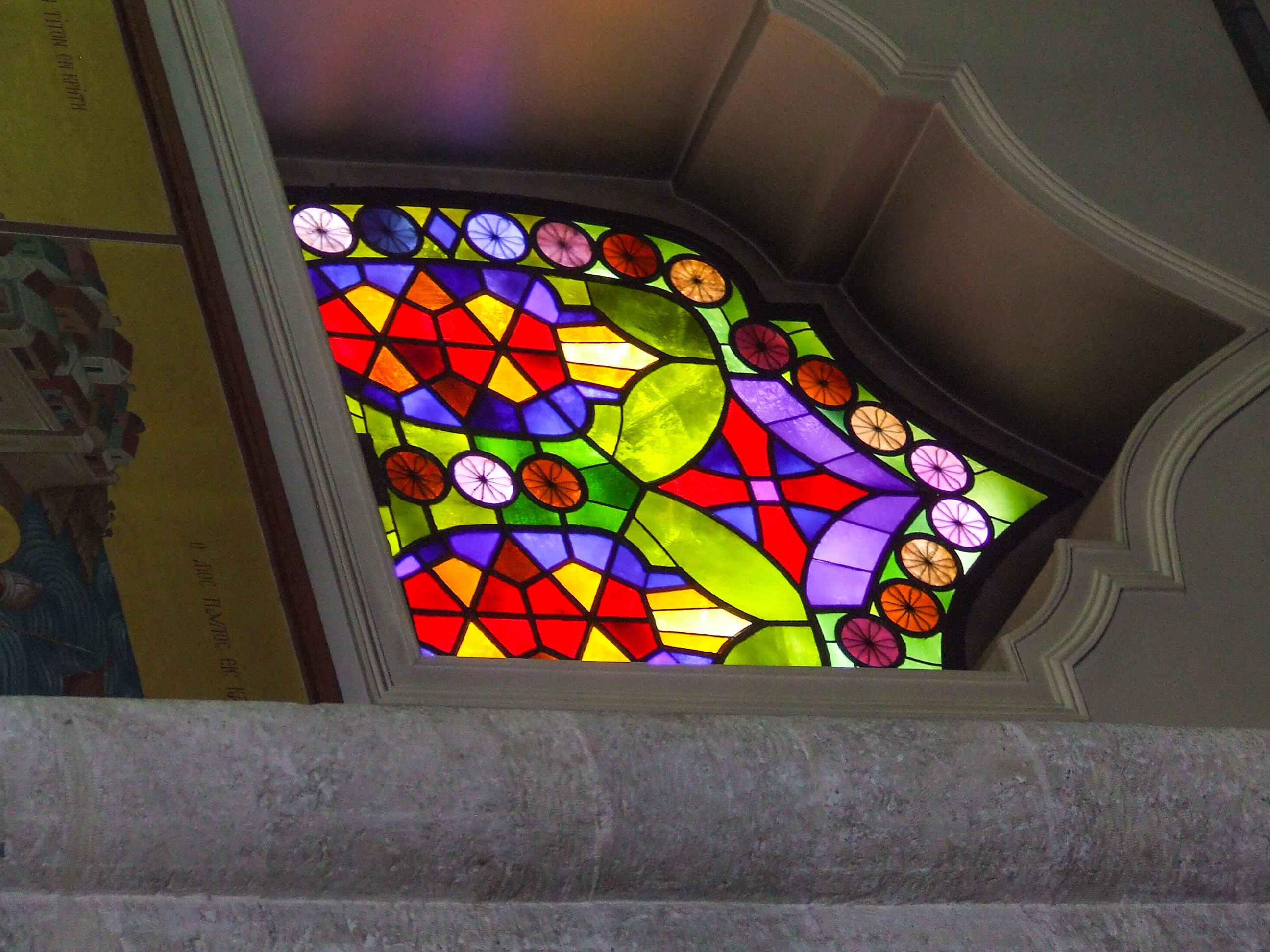 a colorful stained glass window set in a stone archway