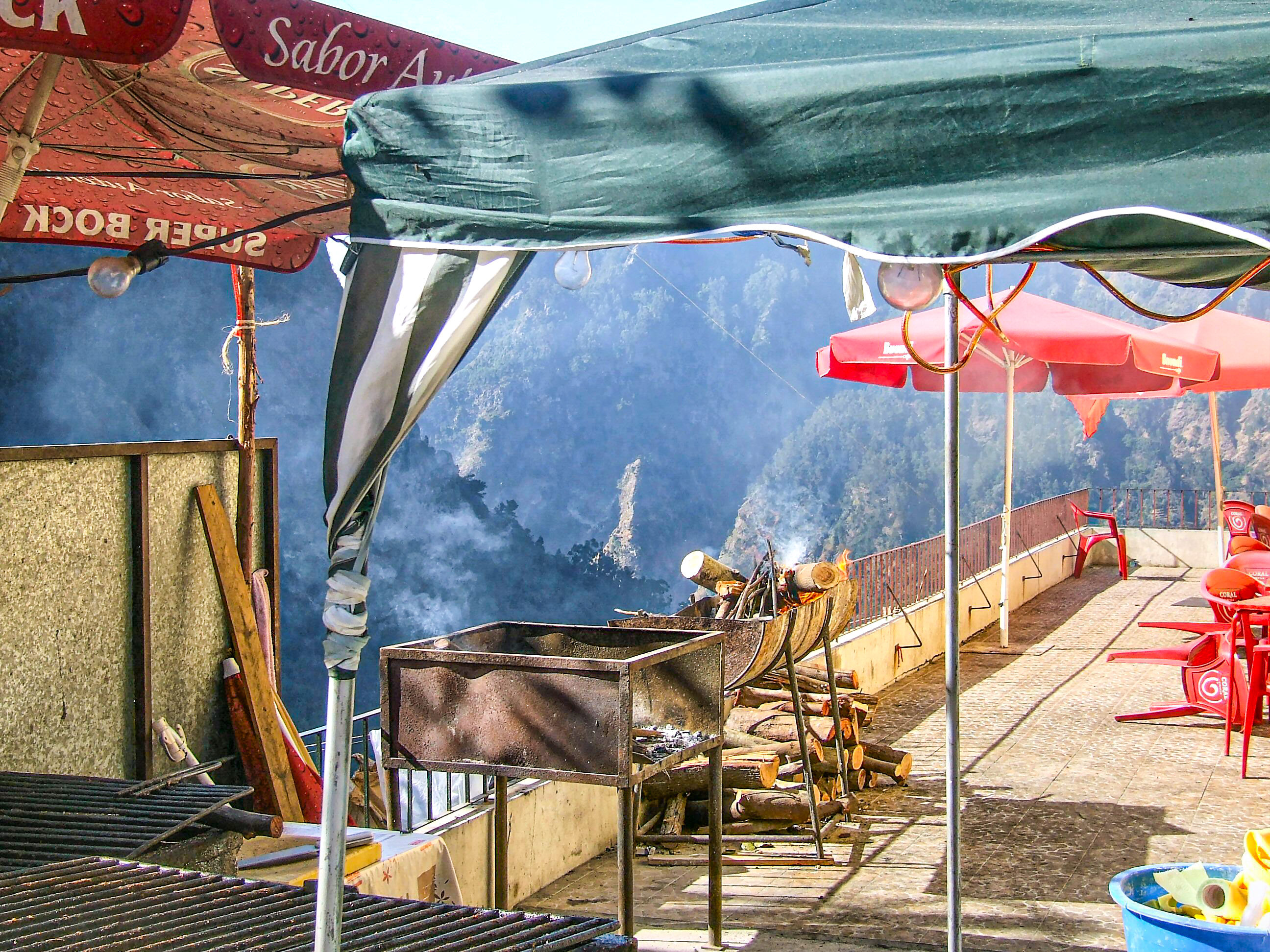 outdoor cooking area with grills and umbrellas