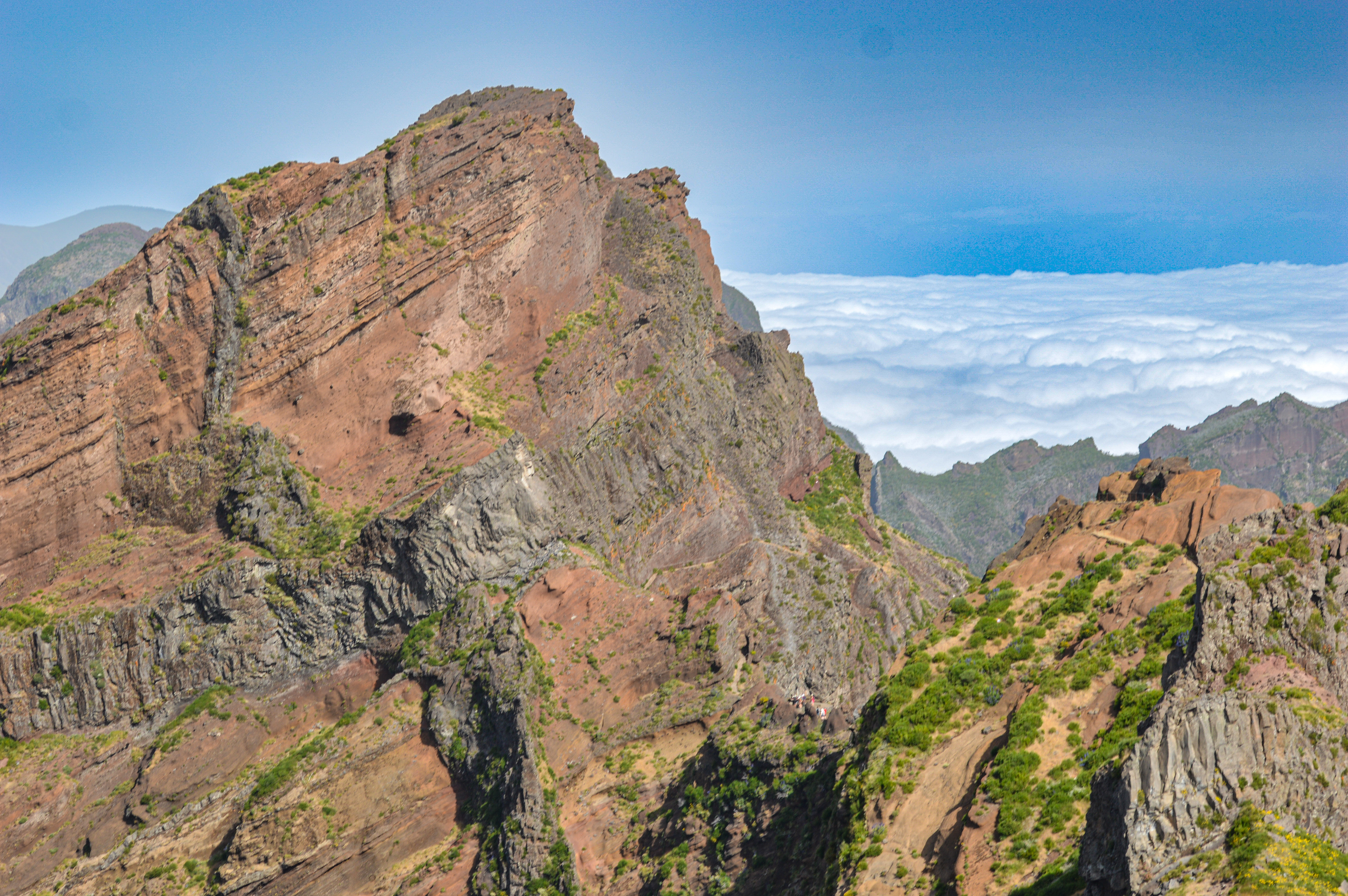 The sky is clear, and a layer of clouds is visible below the mountain peaks