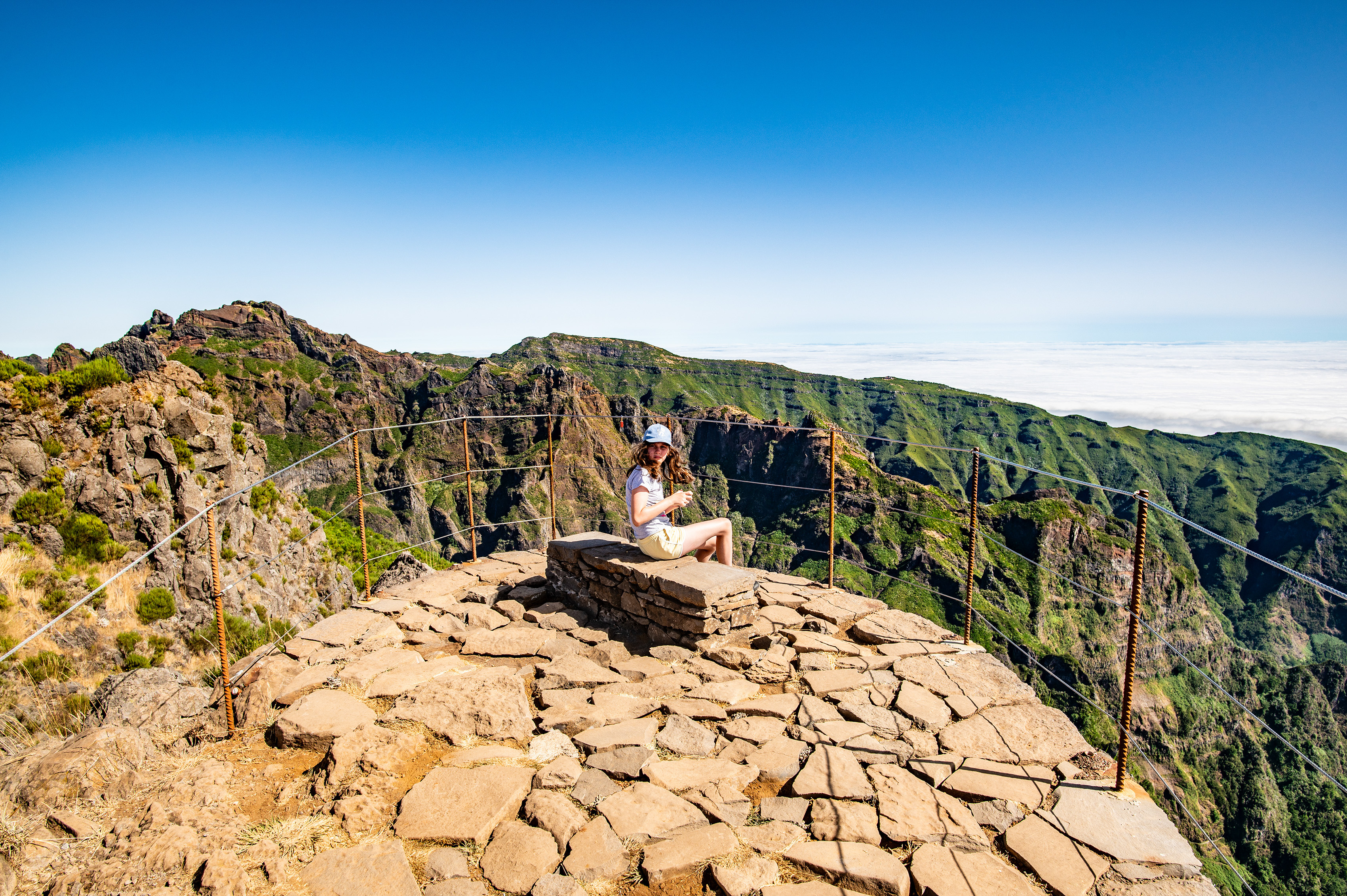 a person sitting on a rocky outcrop at a high altitude
