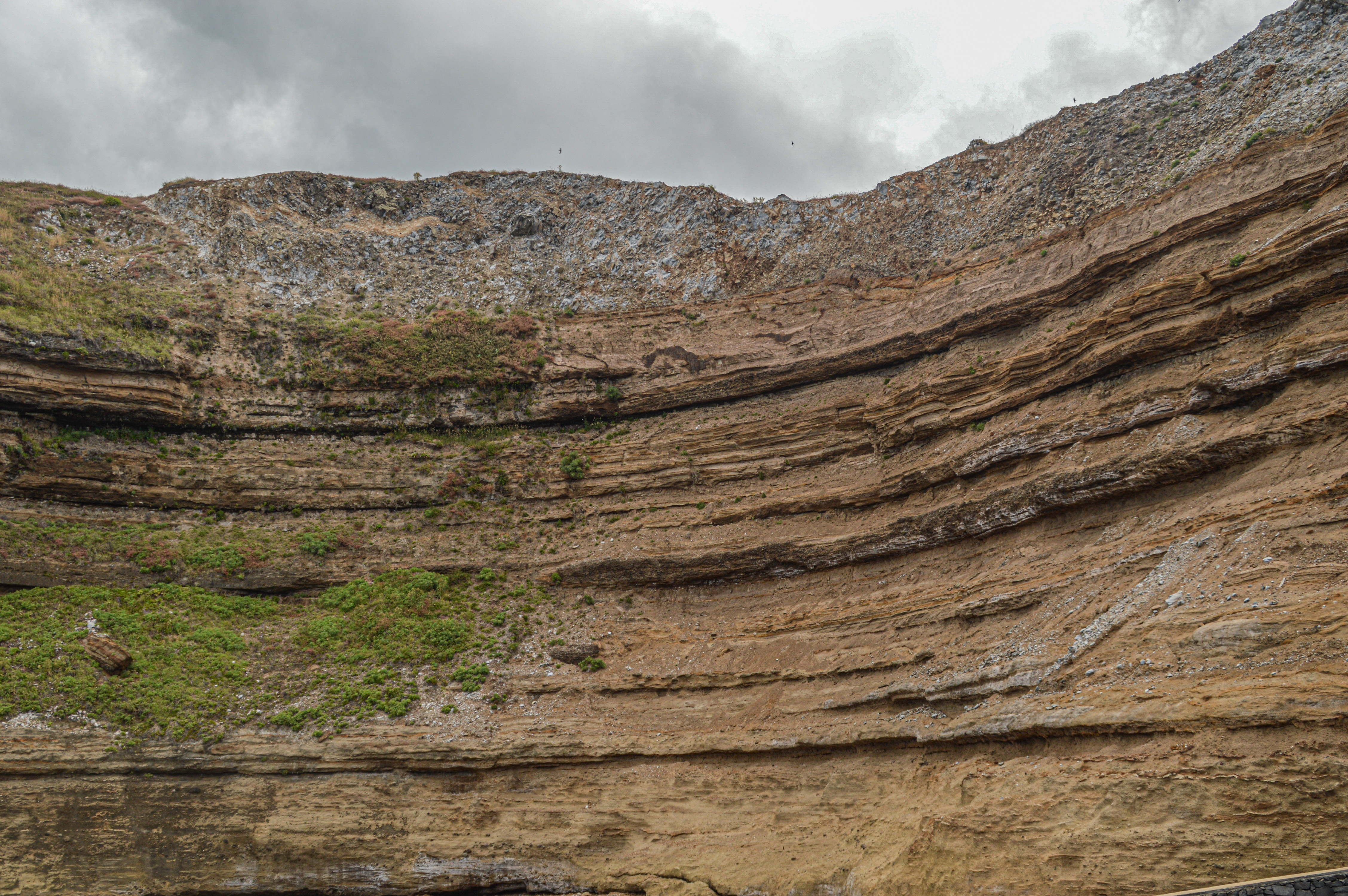 steep, stratified rock face with distinct horizontal layers