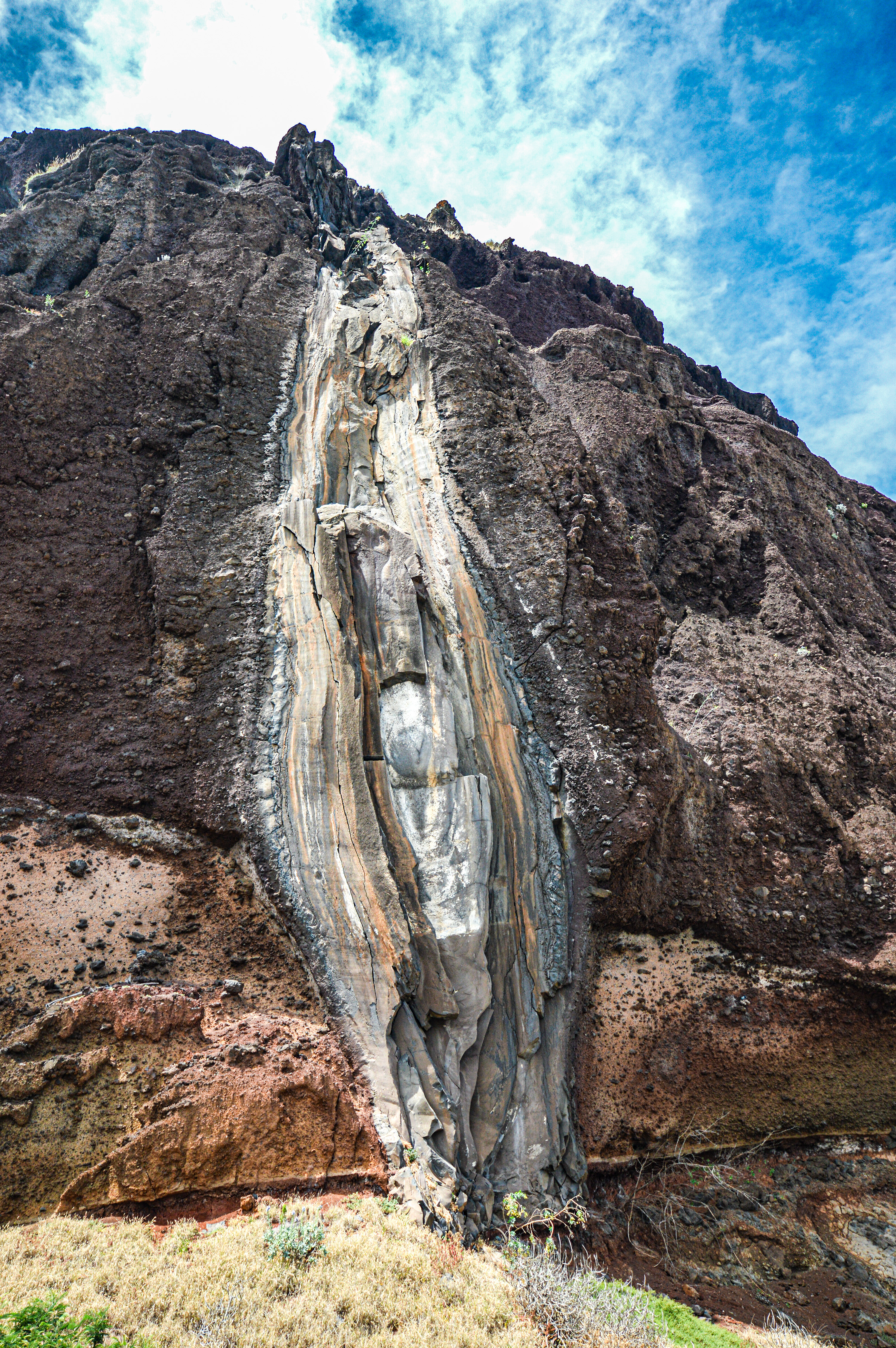 rocky cliff with a prominent, vertical streak running down its center