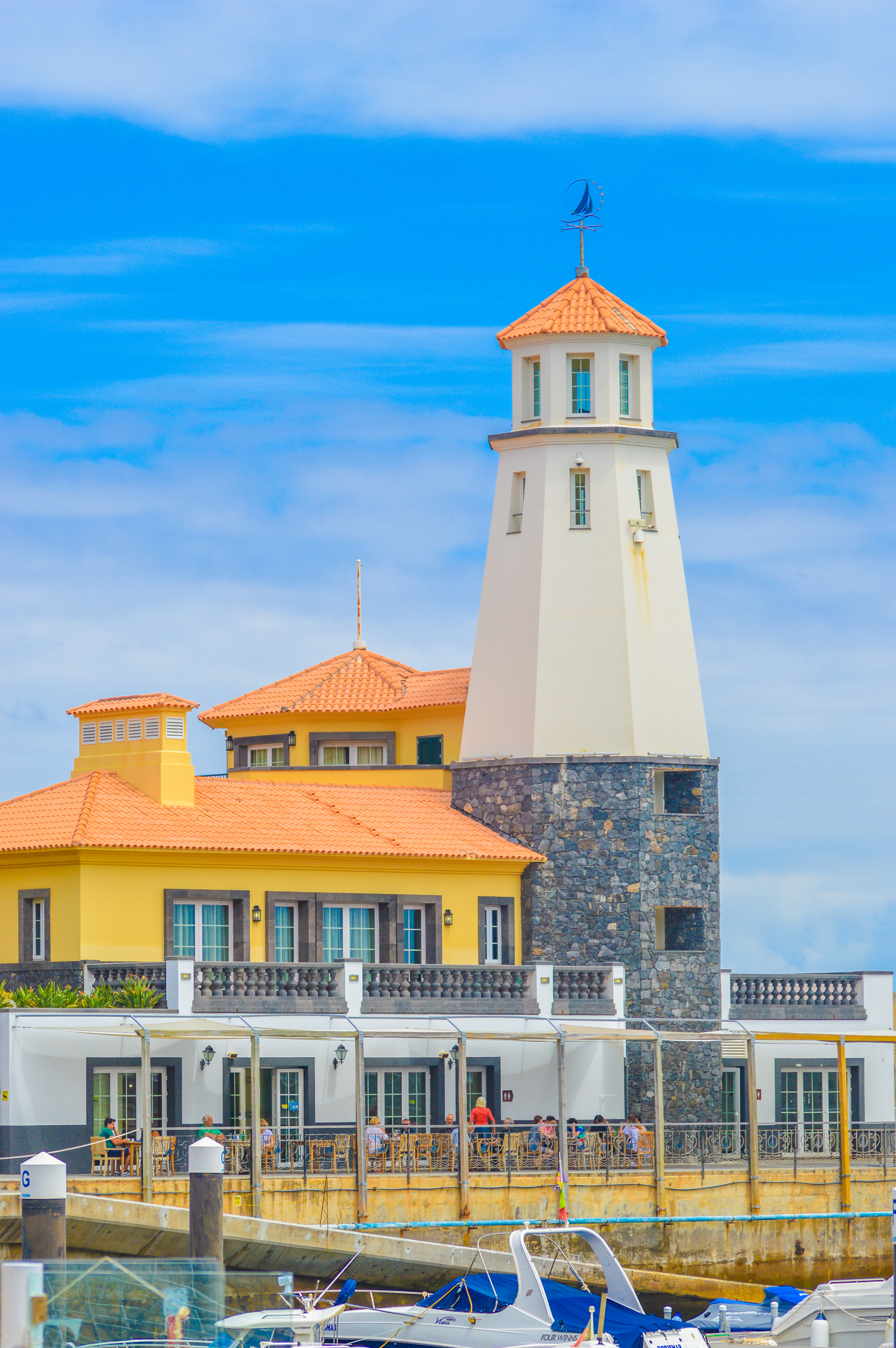 lighthouse with a white structure and a red-tiled roof