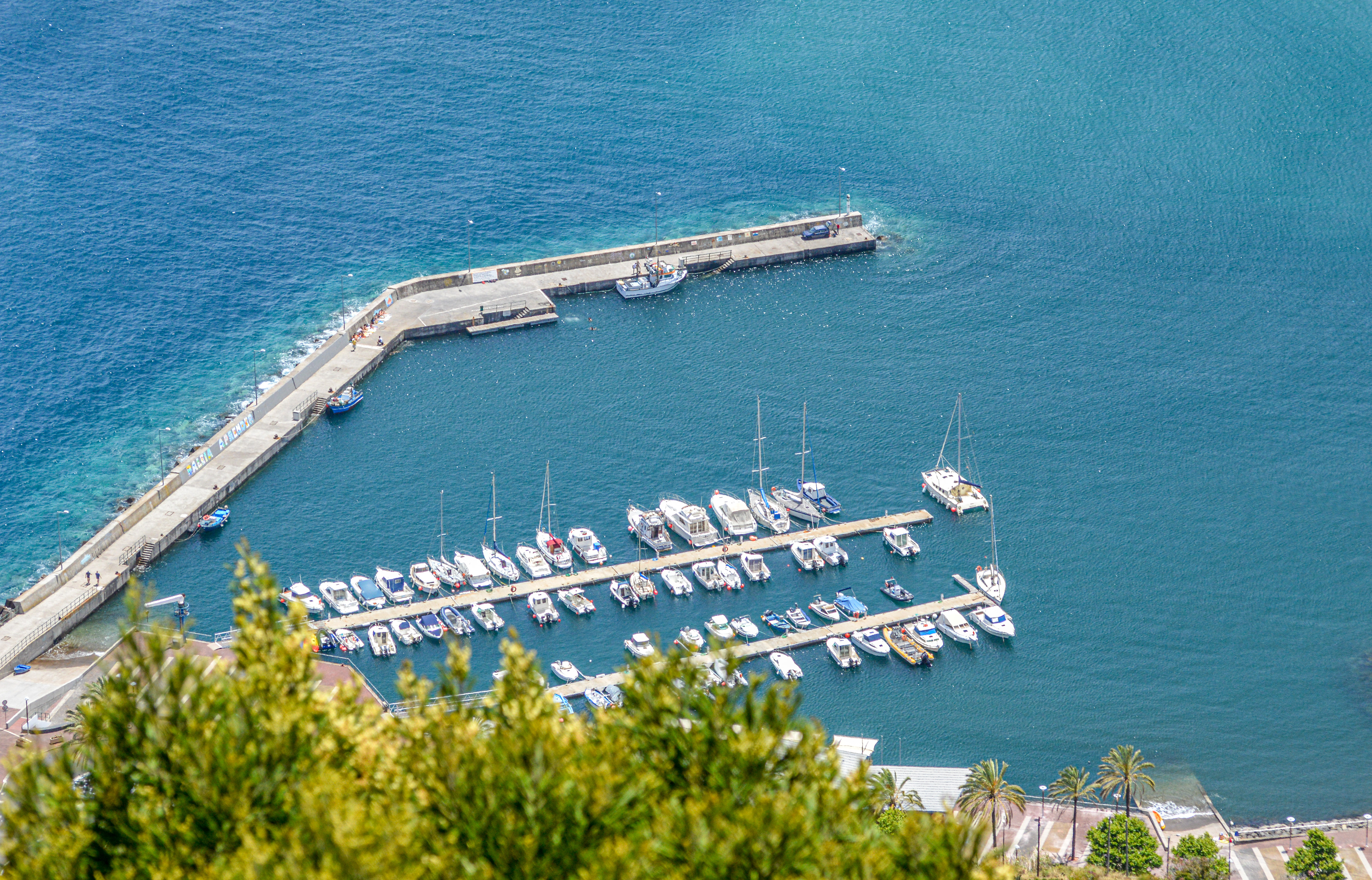 a long pier extending into clear blue water