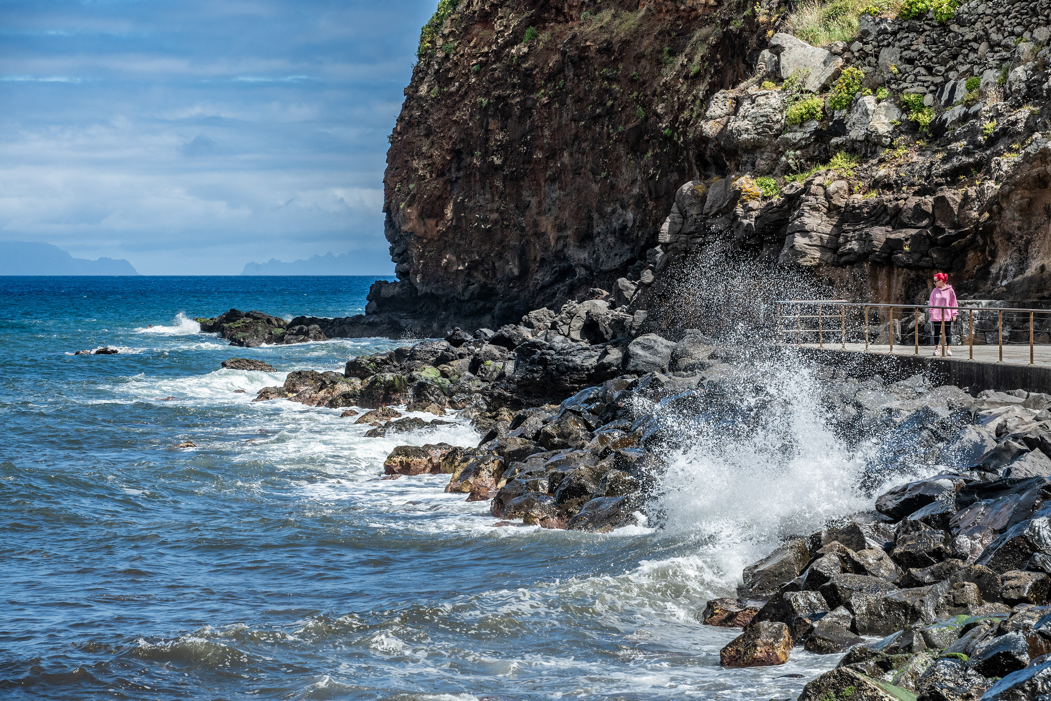 standing on a path near a rocky cliff