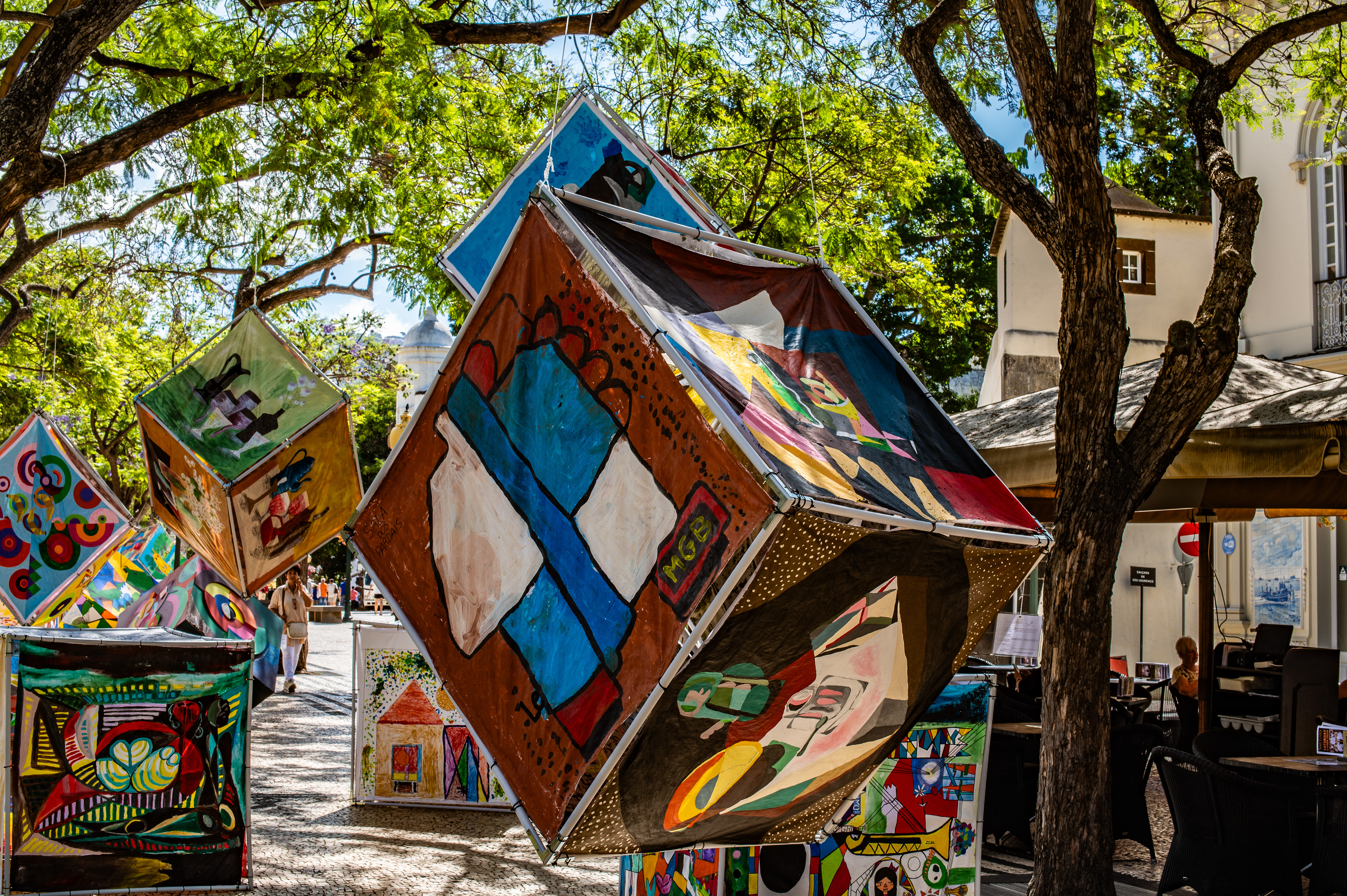 geometric-shaped art installations hanging from trees