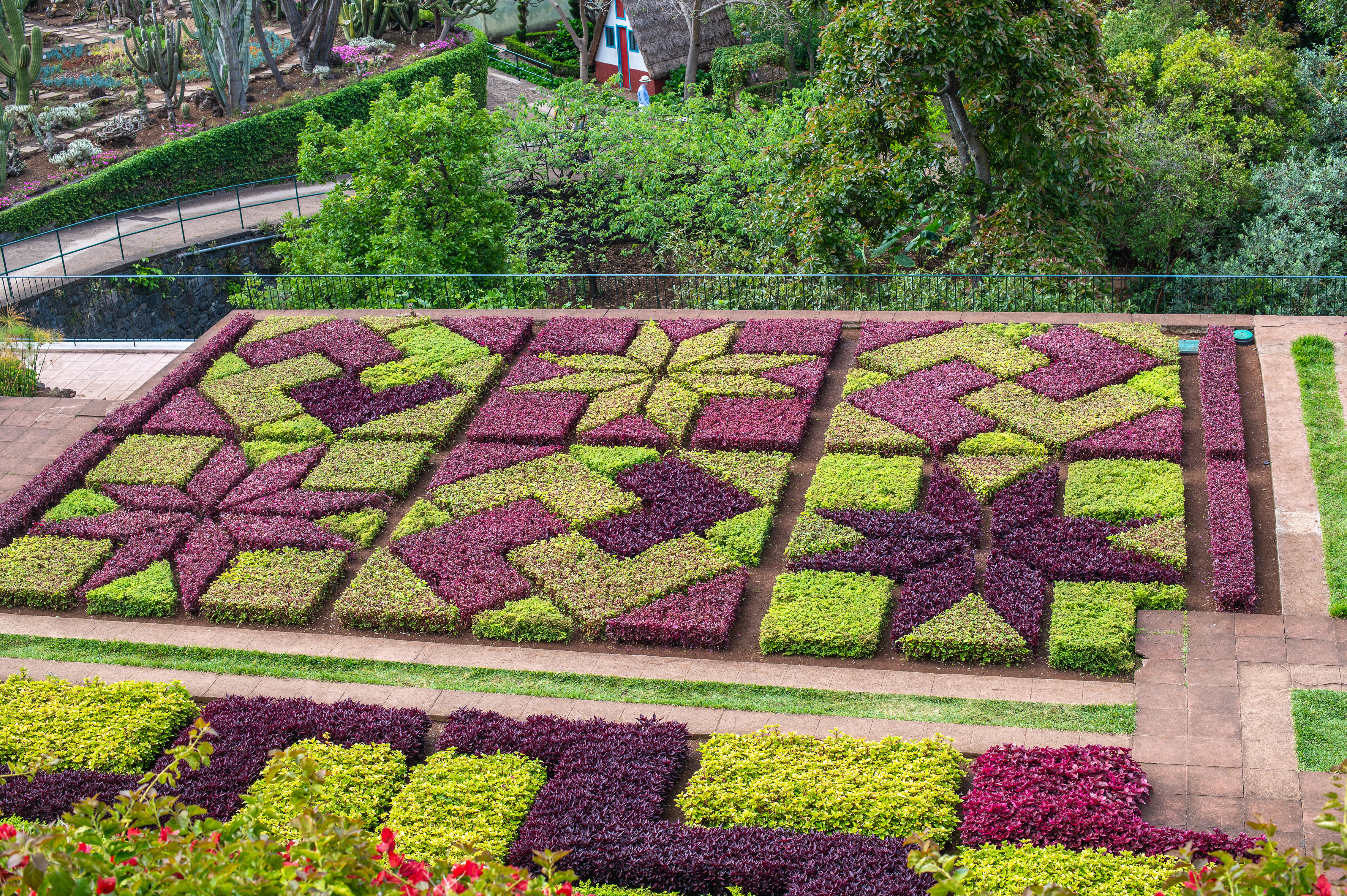 landscaped garden with intricate geometric patterns formed by colorful plants.