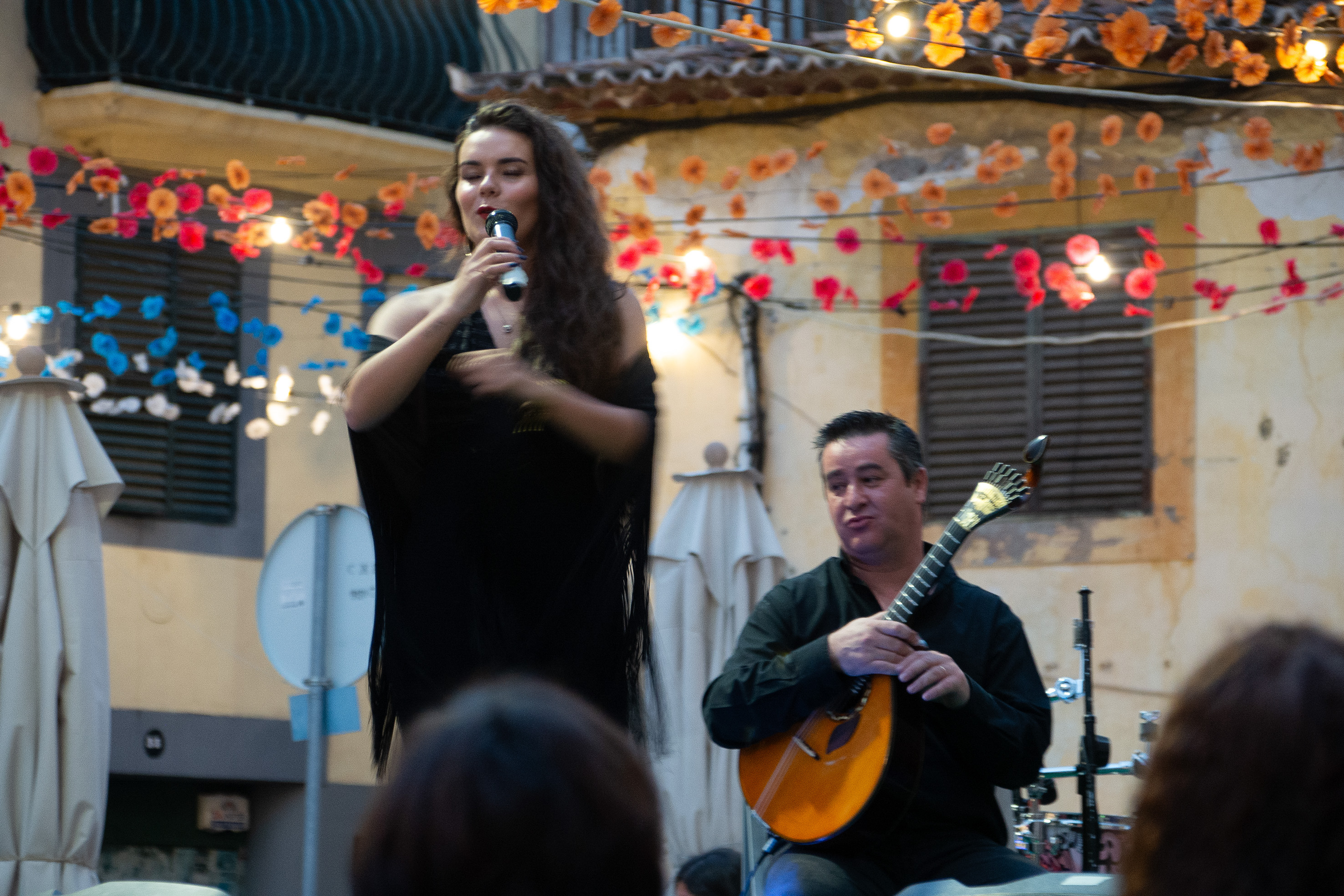 woman singing into a microphone and a man playing a guitar