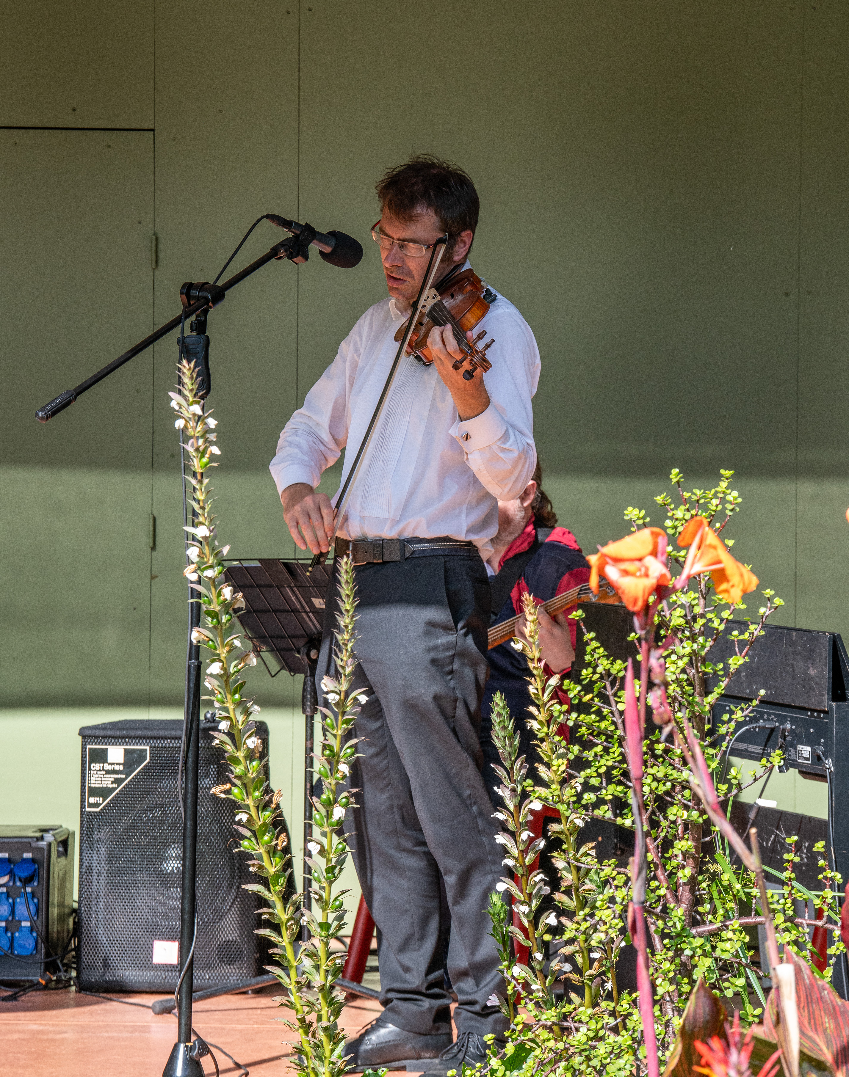 A man is playing the violin on stage