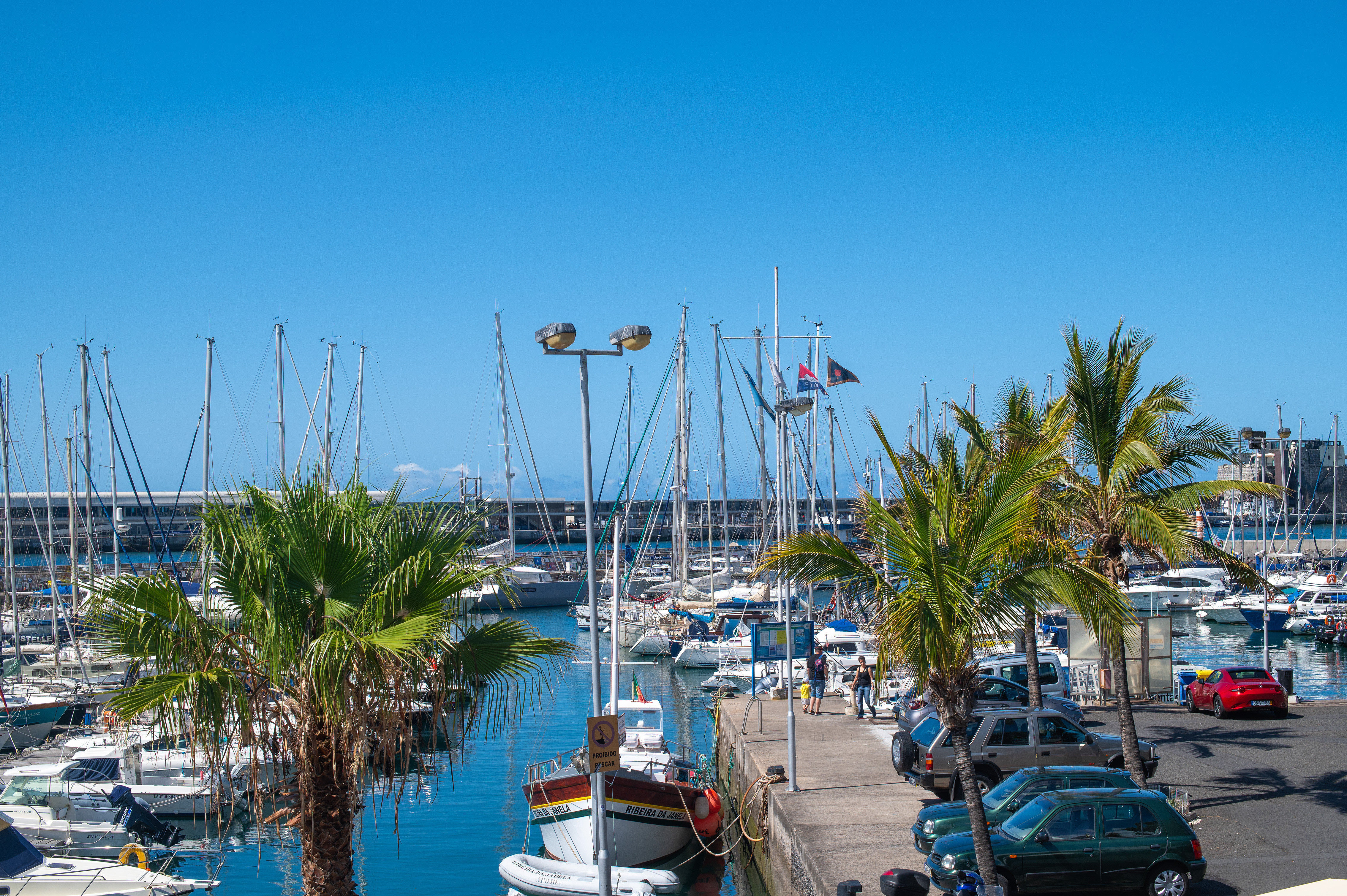 a few people are walking along the dock