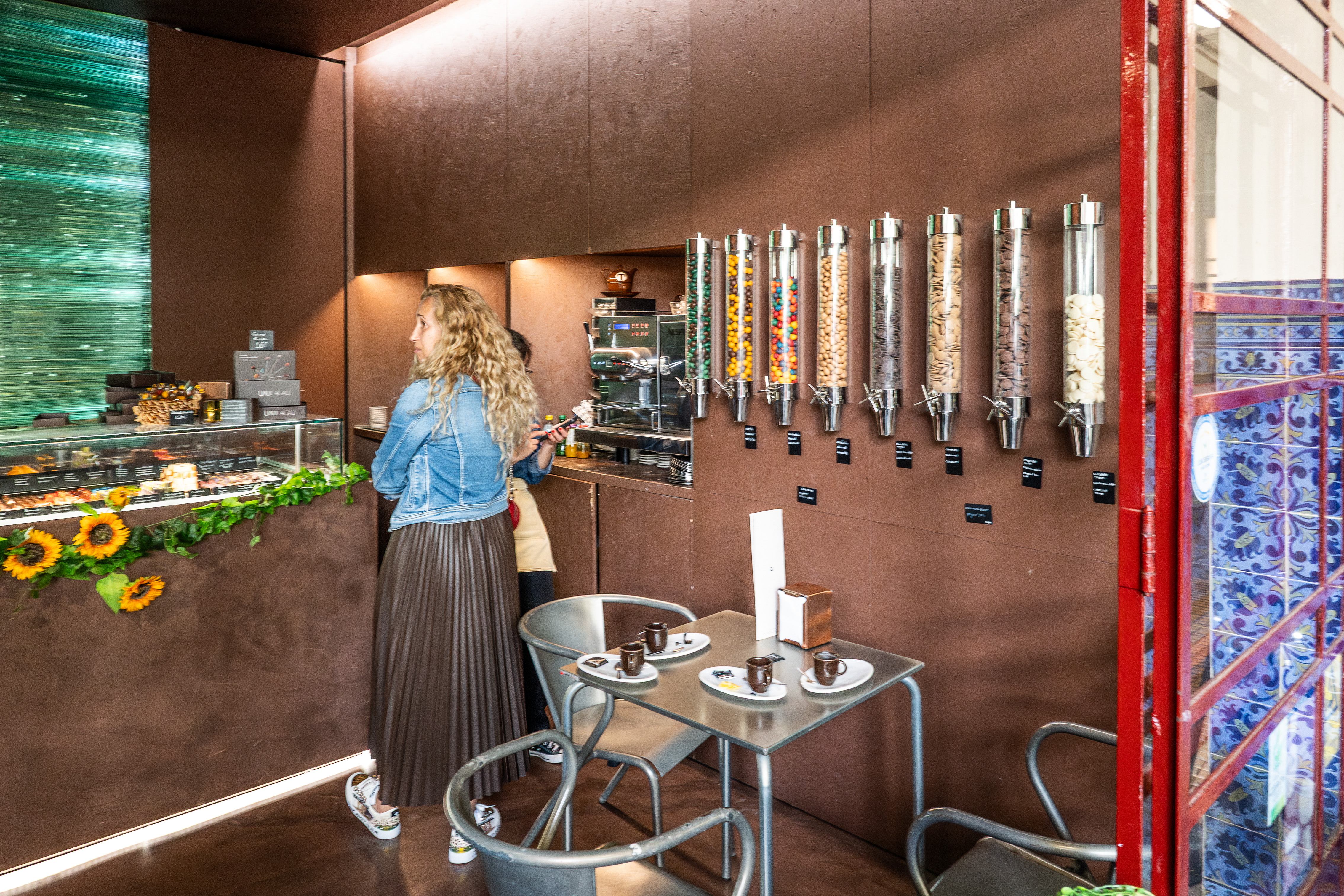 a modern, stylish cafÃ© with a woman standing at the counter