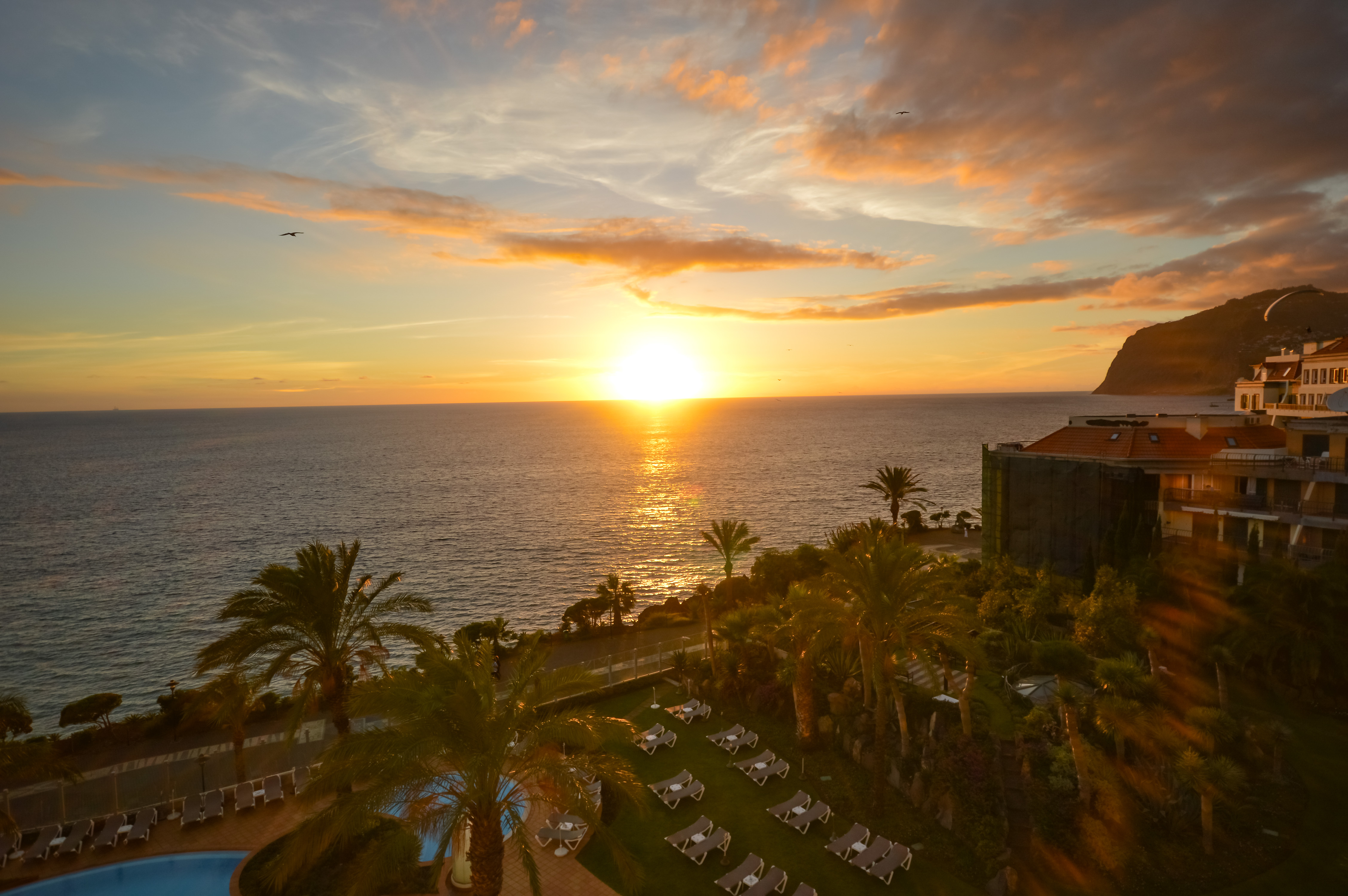 The sun is setting over the calm ocean