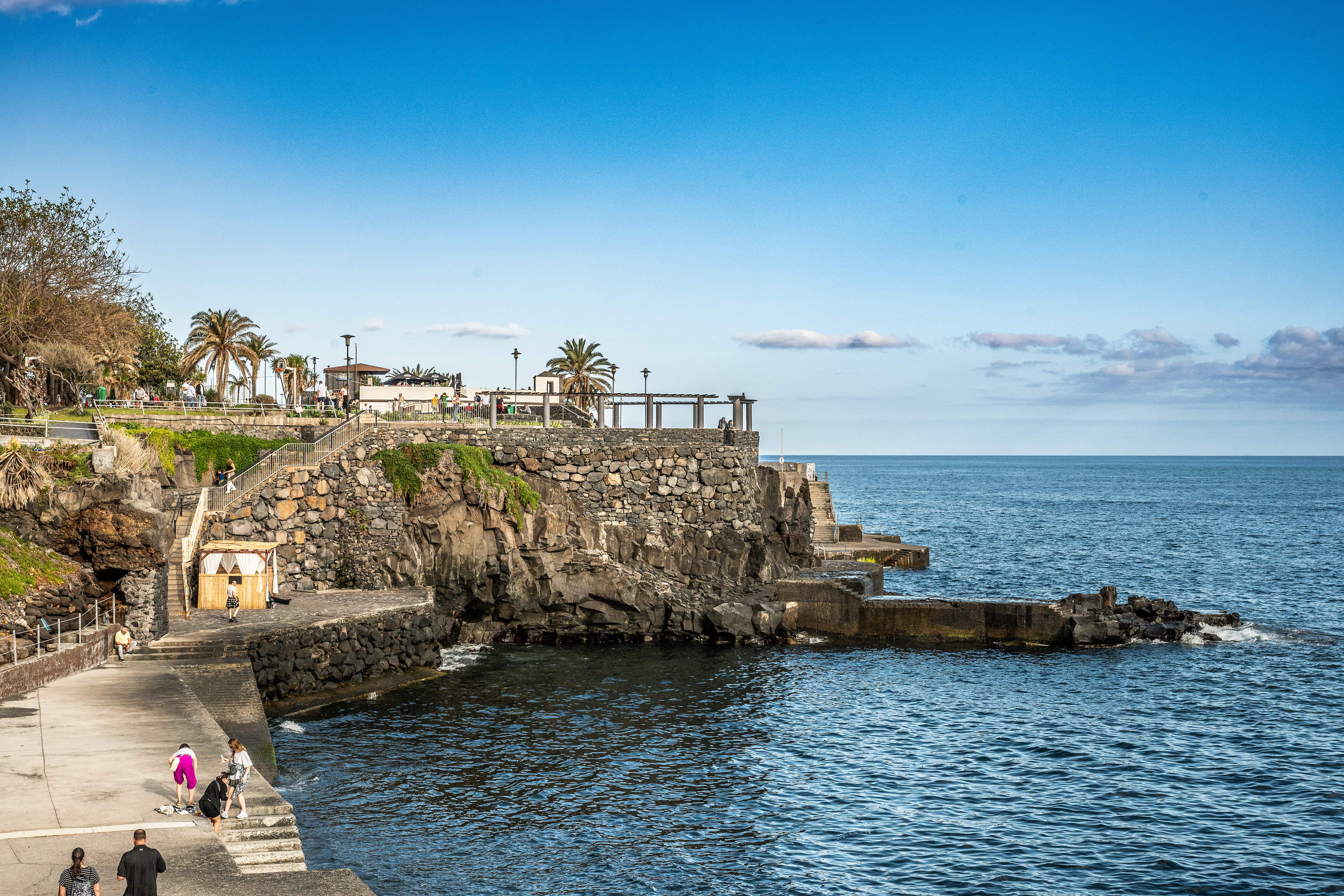 rocky shoreline and a stone pier extending into the ocean