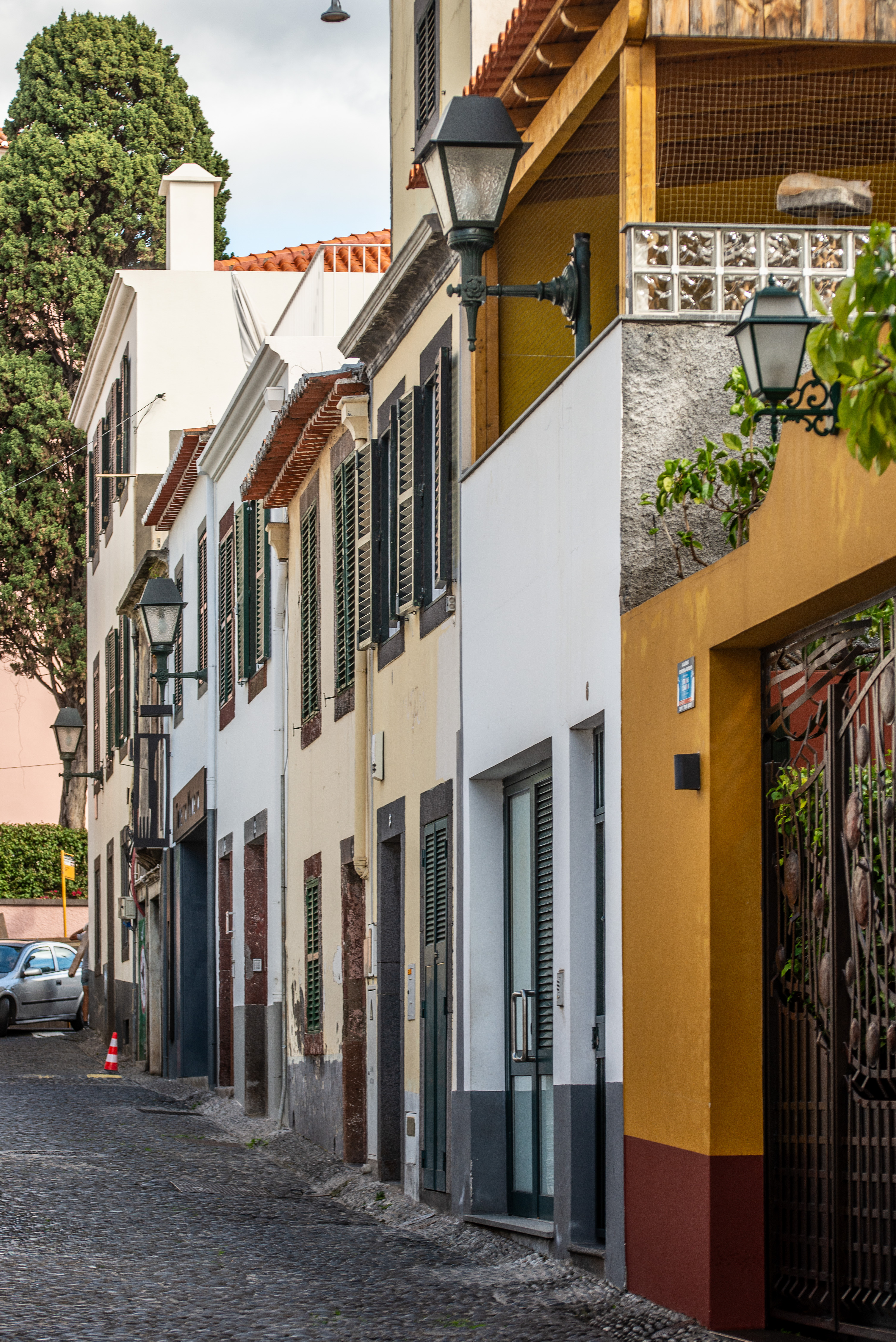 colorful facades, mostly white and yellow, with dark green shutters and doors
