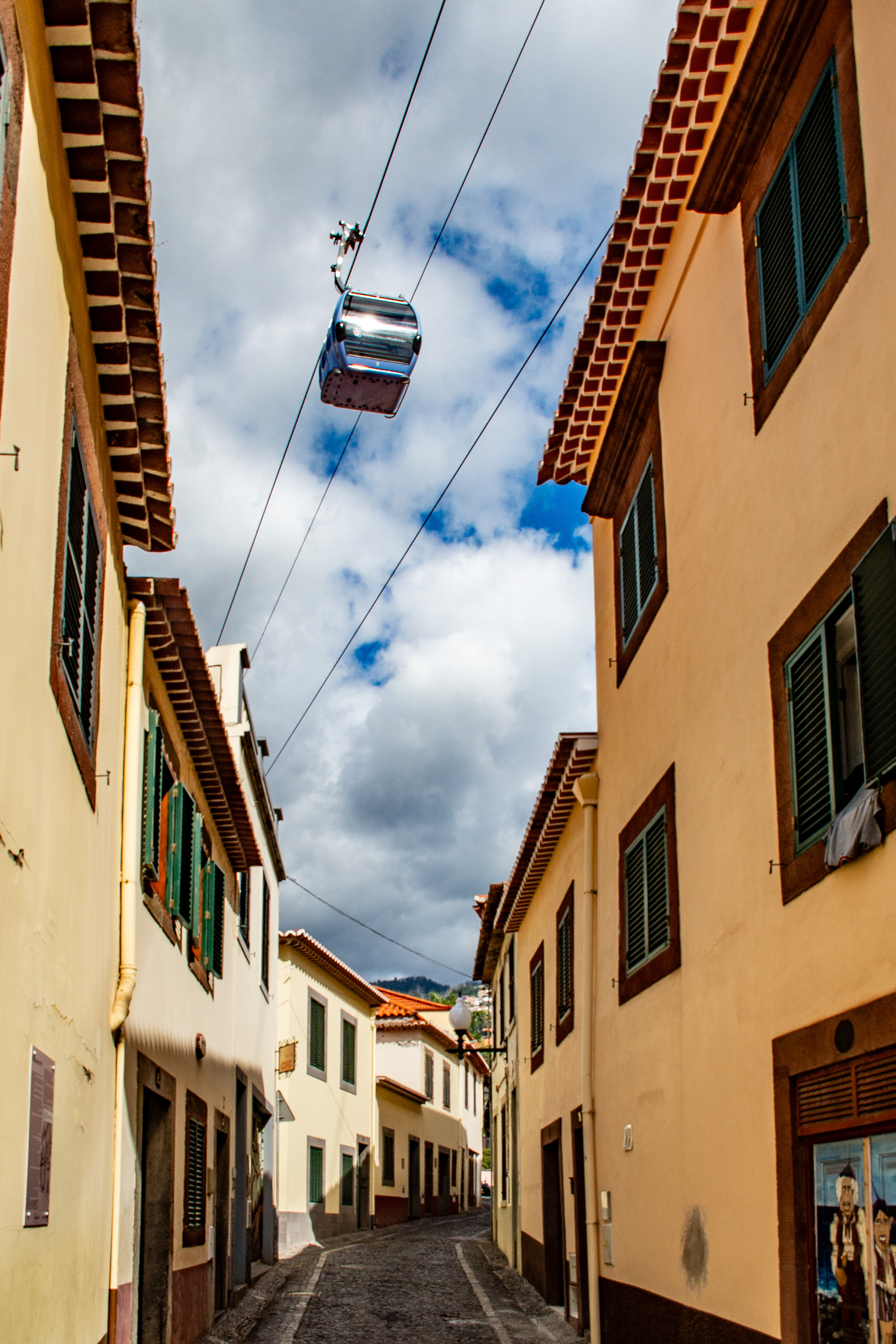Above the street, a cable car is suspended