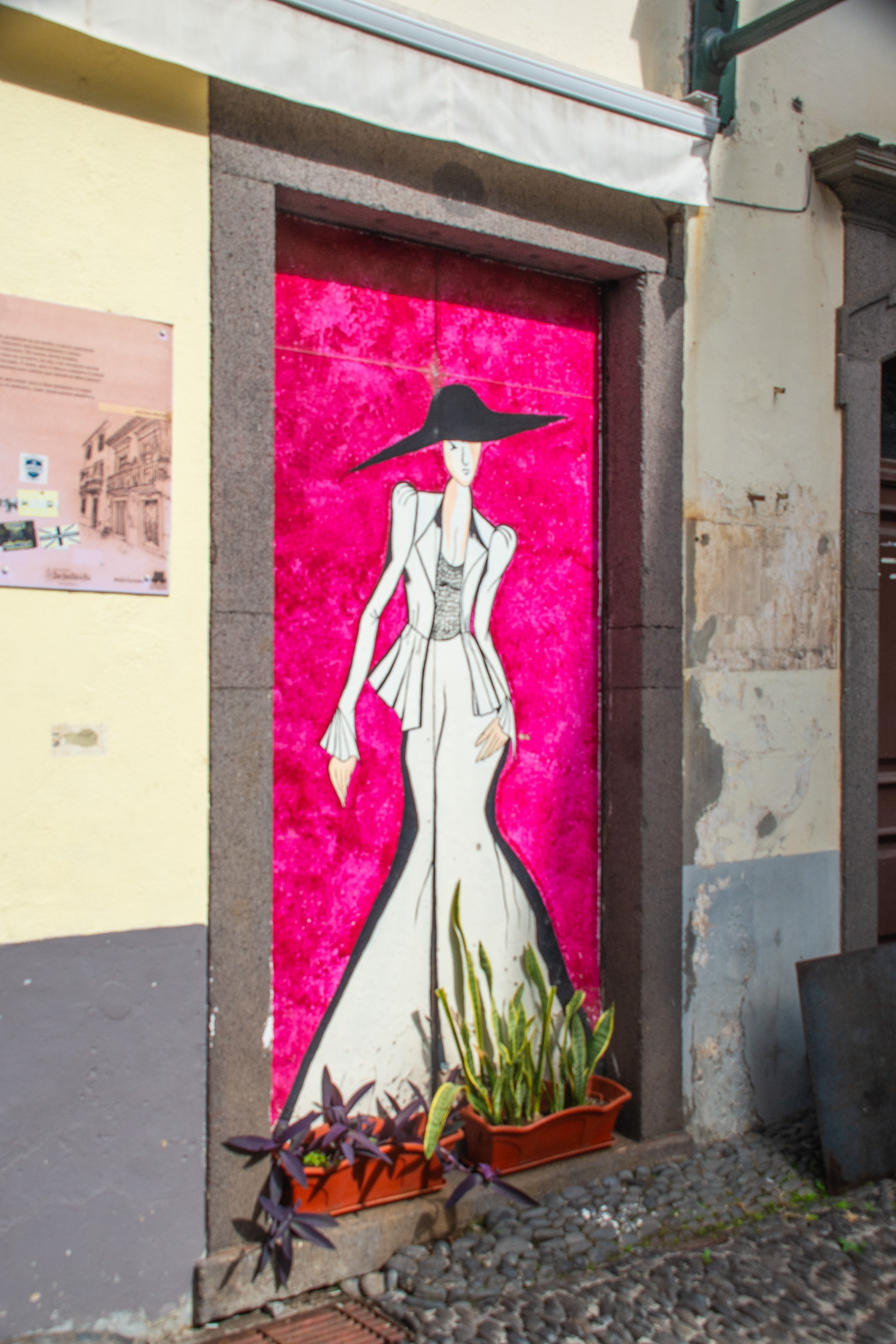 mural features a stylized illustration of a woman wearing a large hat and a flowing dress