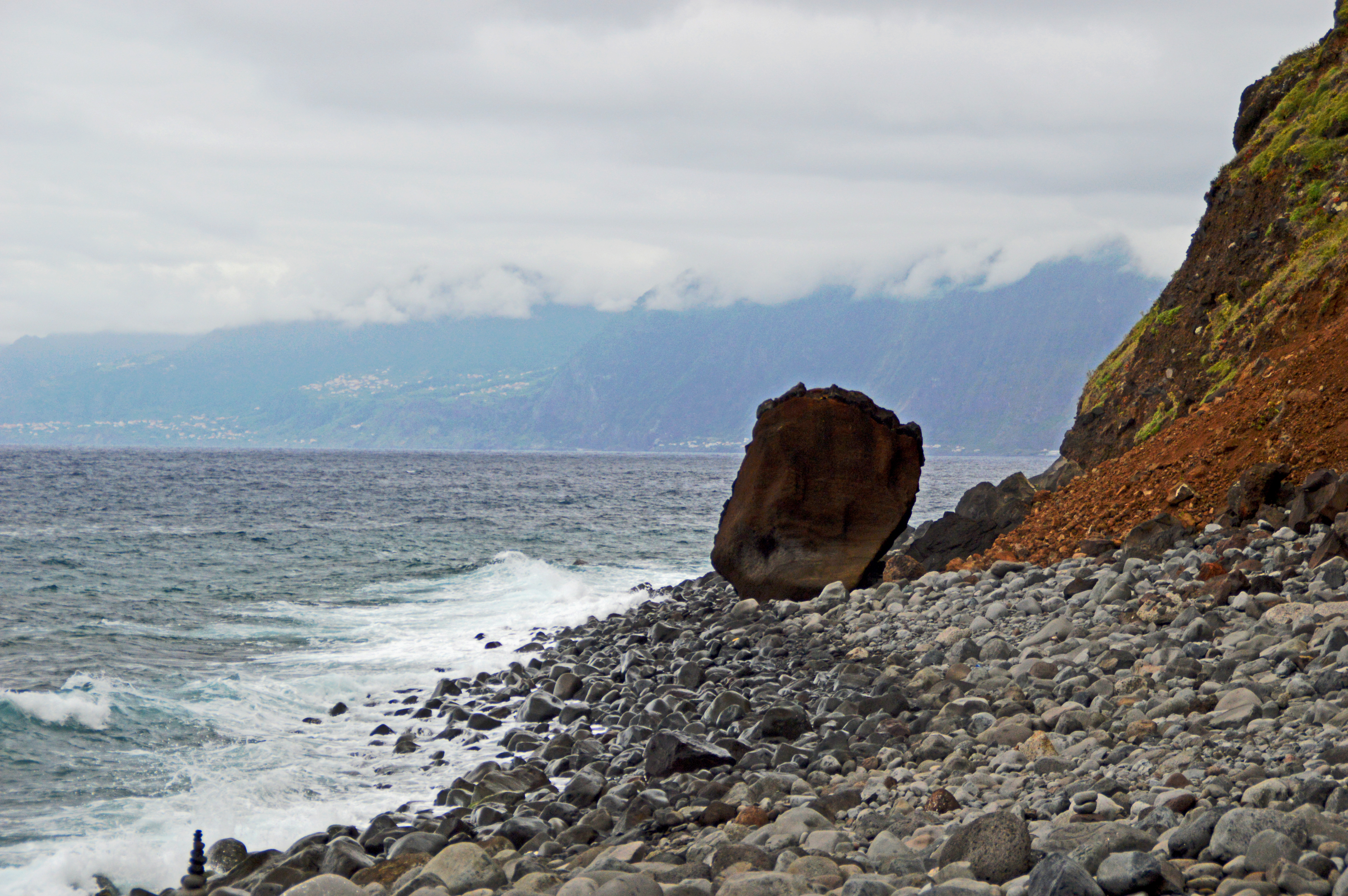 large boulder prominently positioned near the water's edge