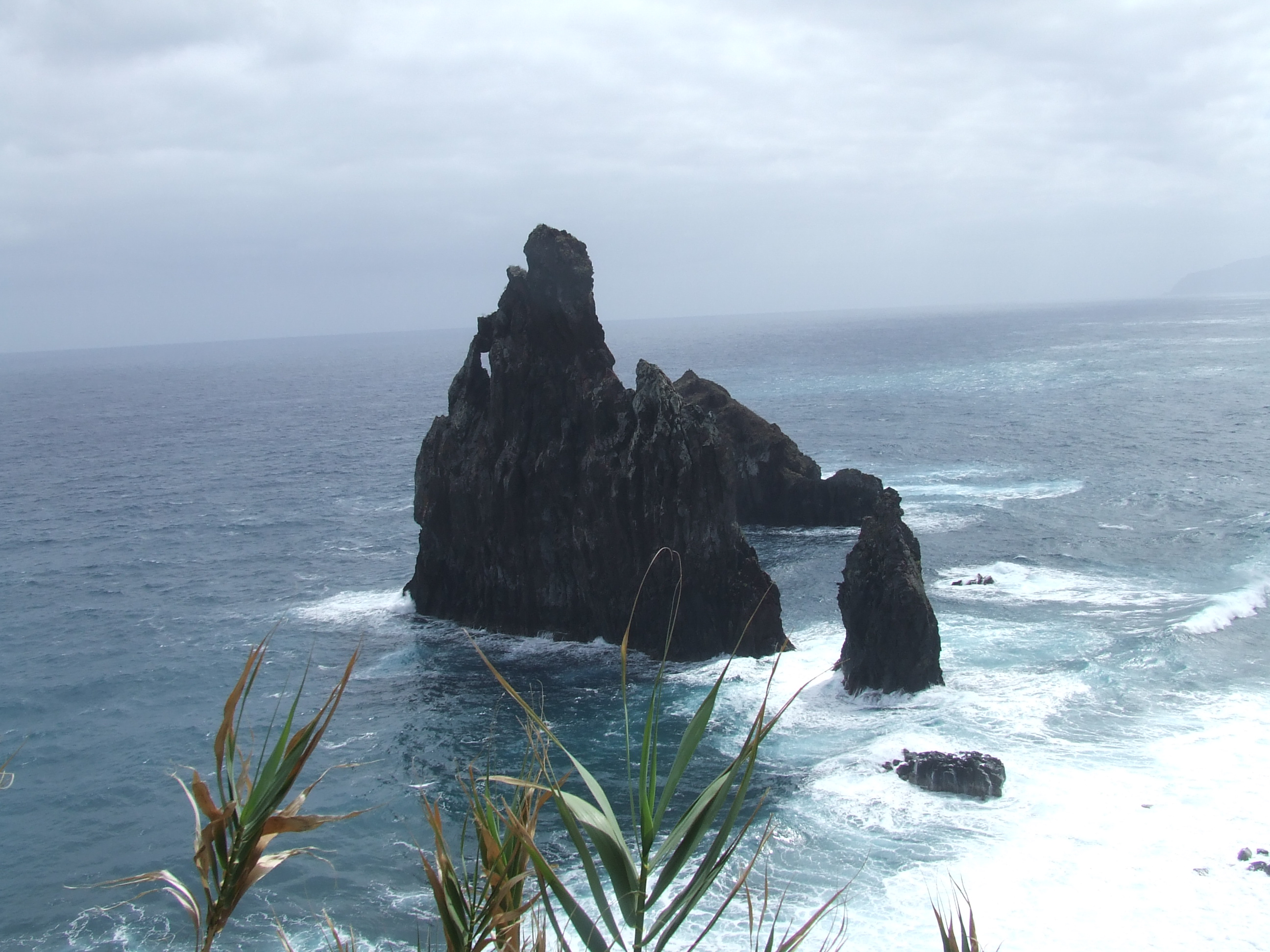 jagged rock formation rising from the ocean