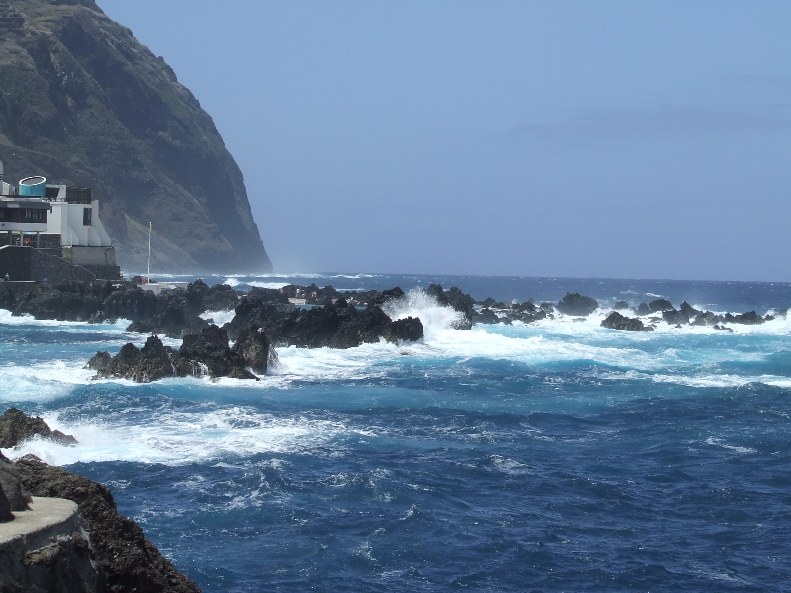 the ocean is relatively calm with some whitecaps visible on the waves