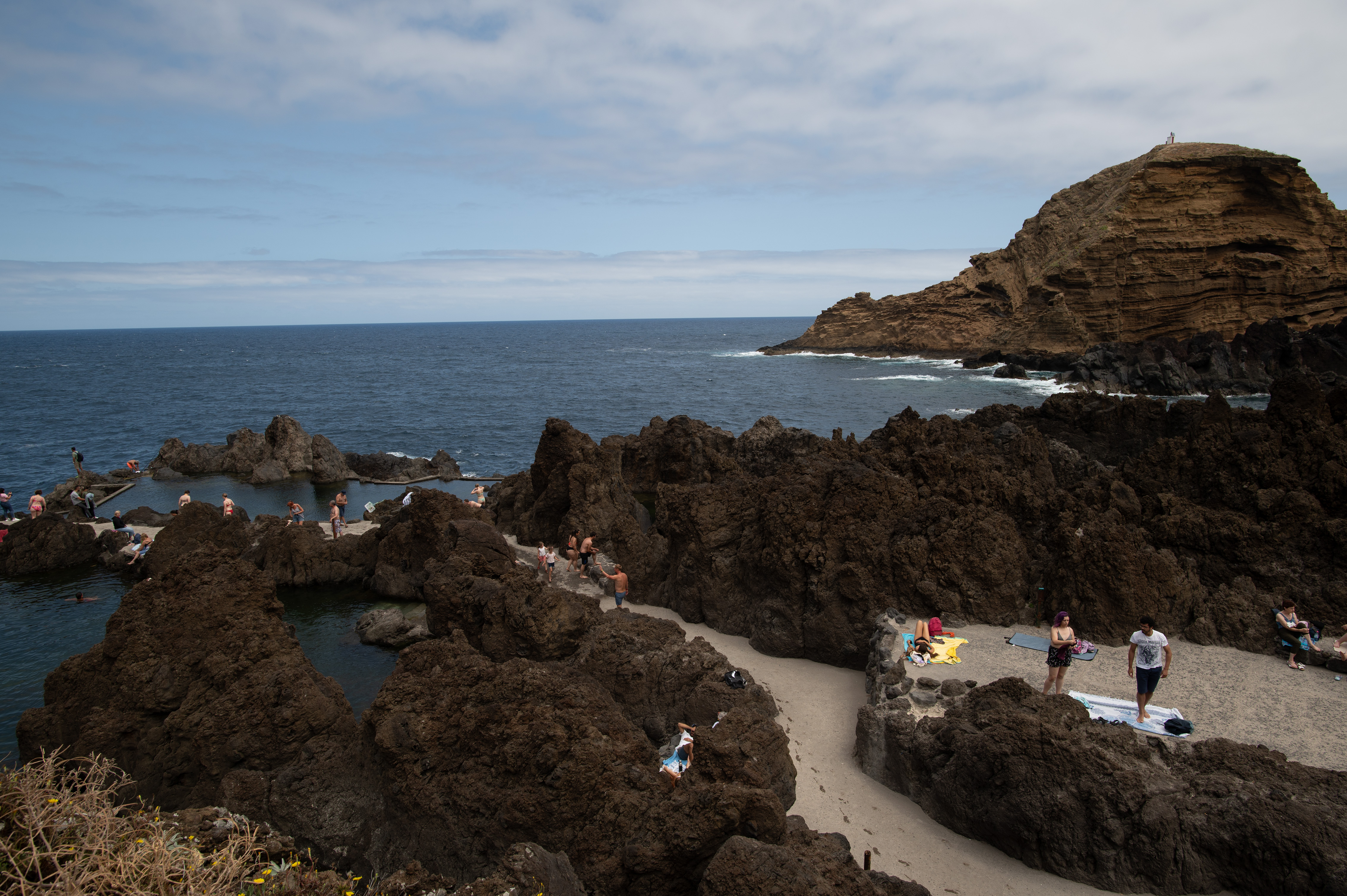 rugged volcanic rock formations and a small stretch of sandy beach