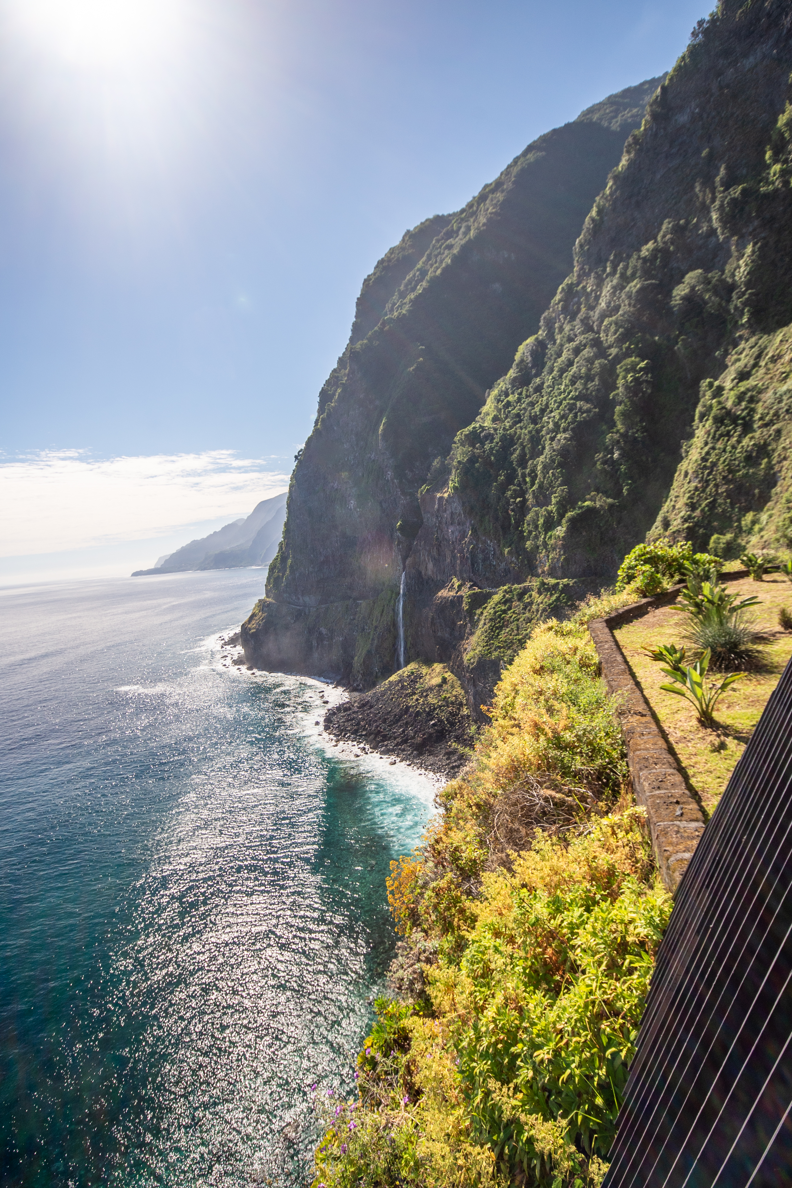 A waterfall cascades down the cliff face