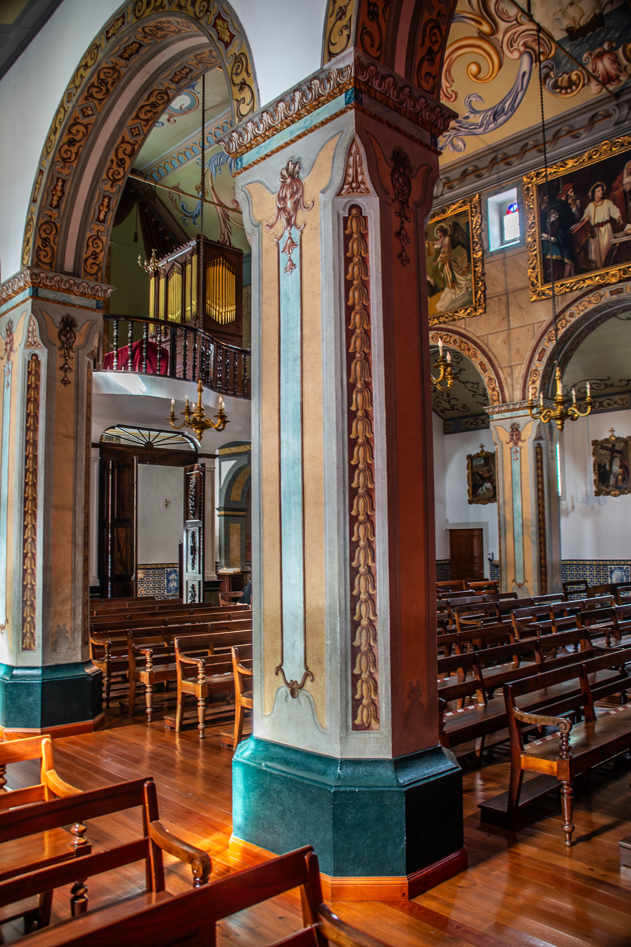 a balcony with a chandelier hanging from the ceiling