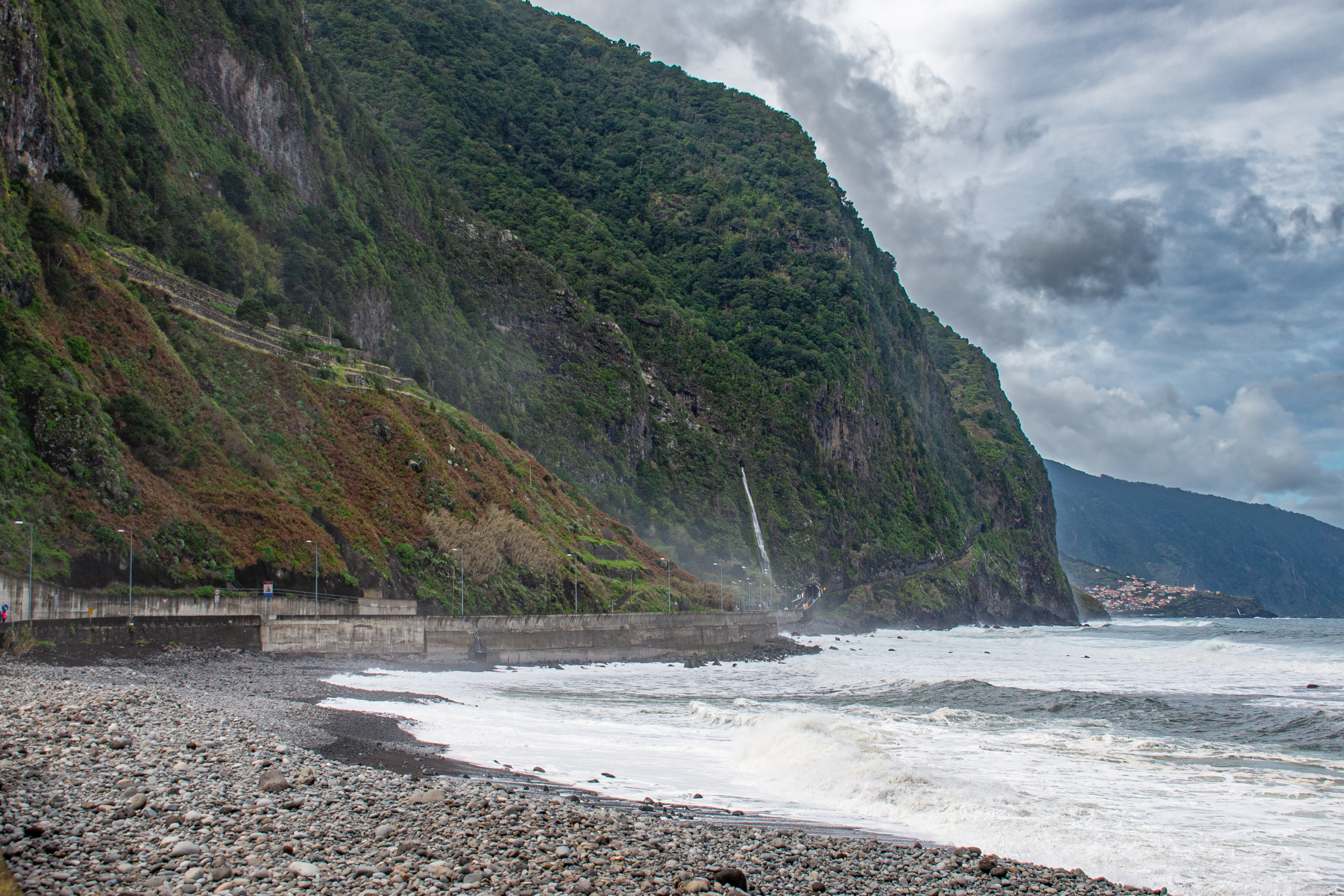 A waterfall cascades down the cliff