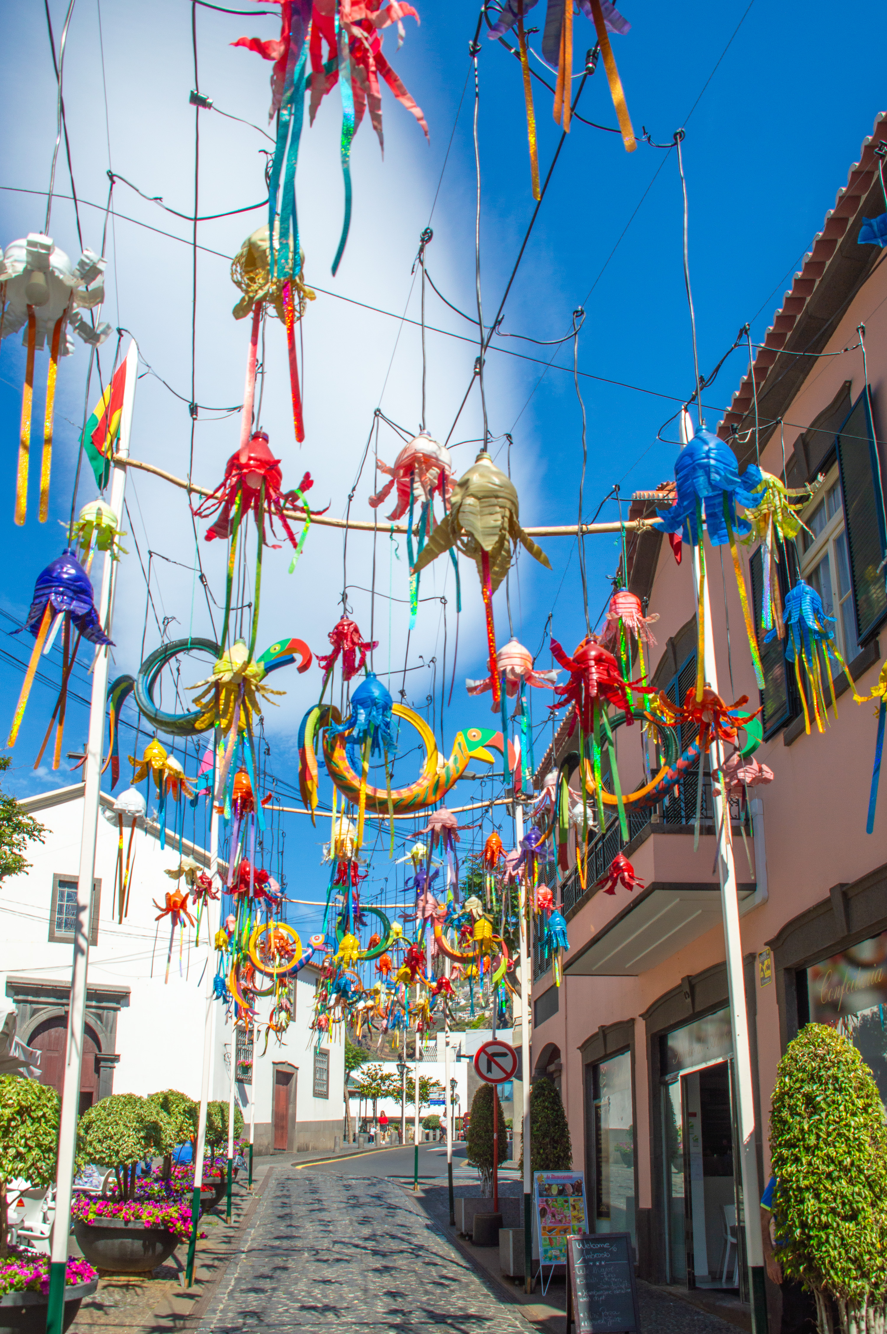 vibrant street adorned with colorful, intricate decorations hanging overhead