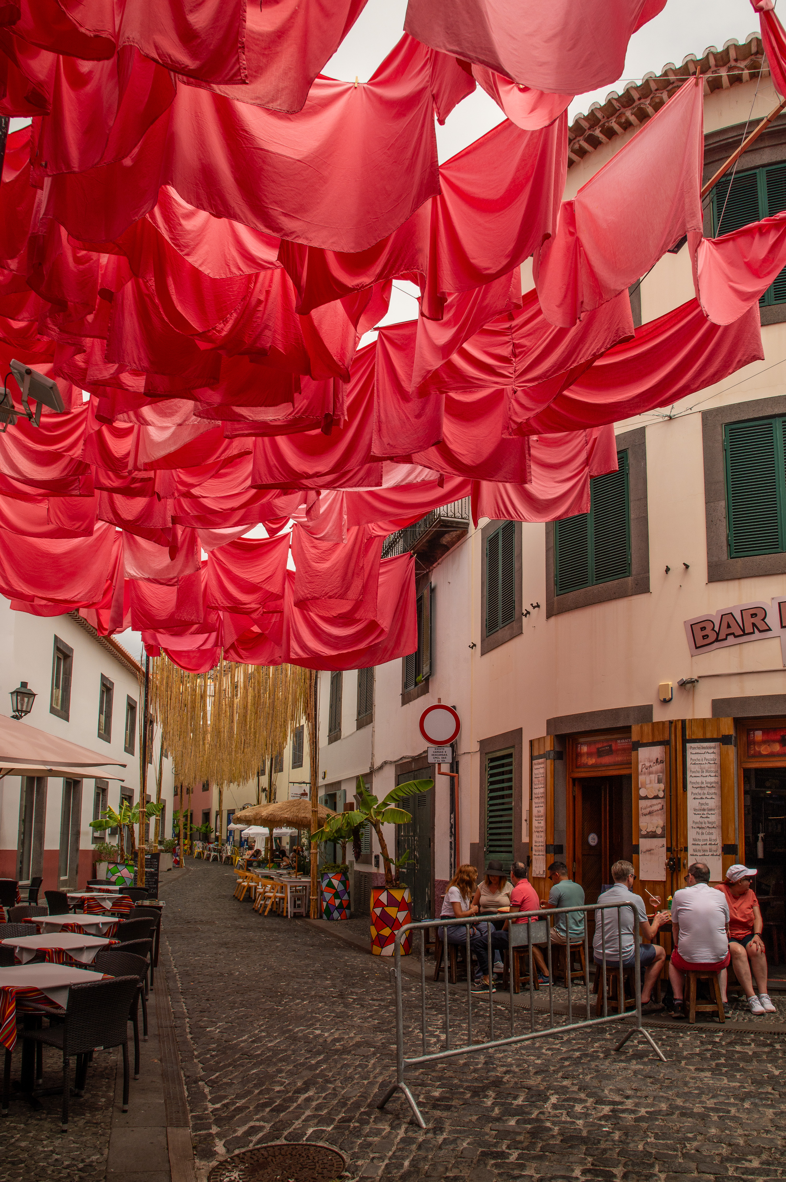 The street is adorned with vibrant red fabric draped overhead