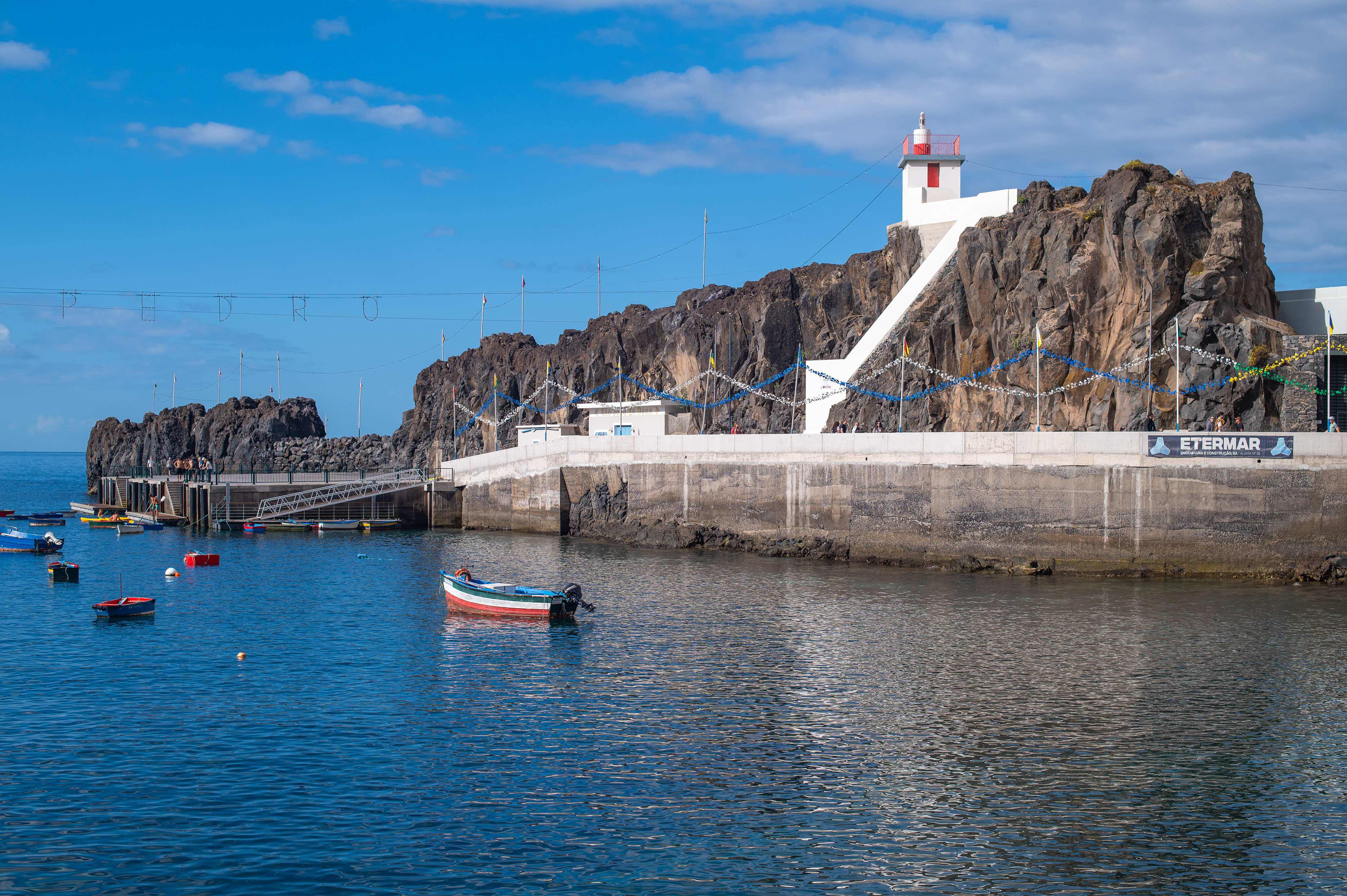 a few small boats are floating on the calm water