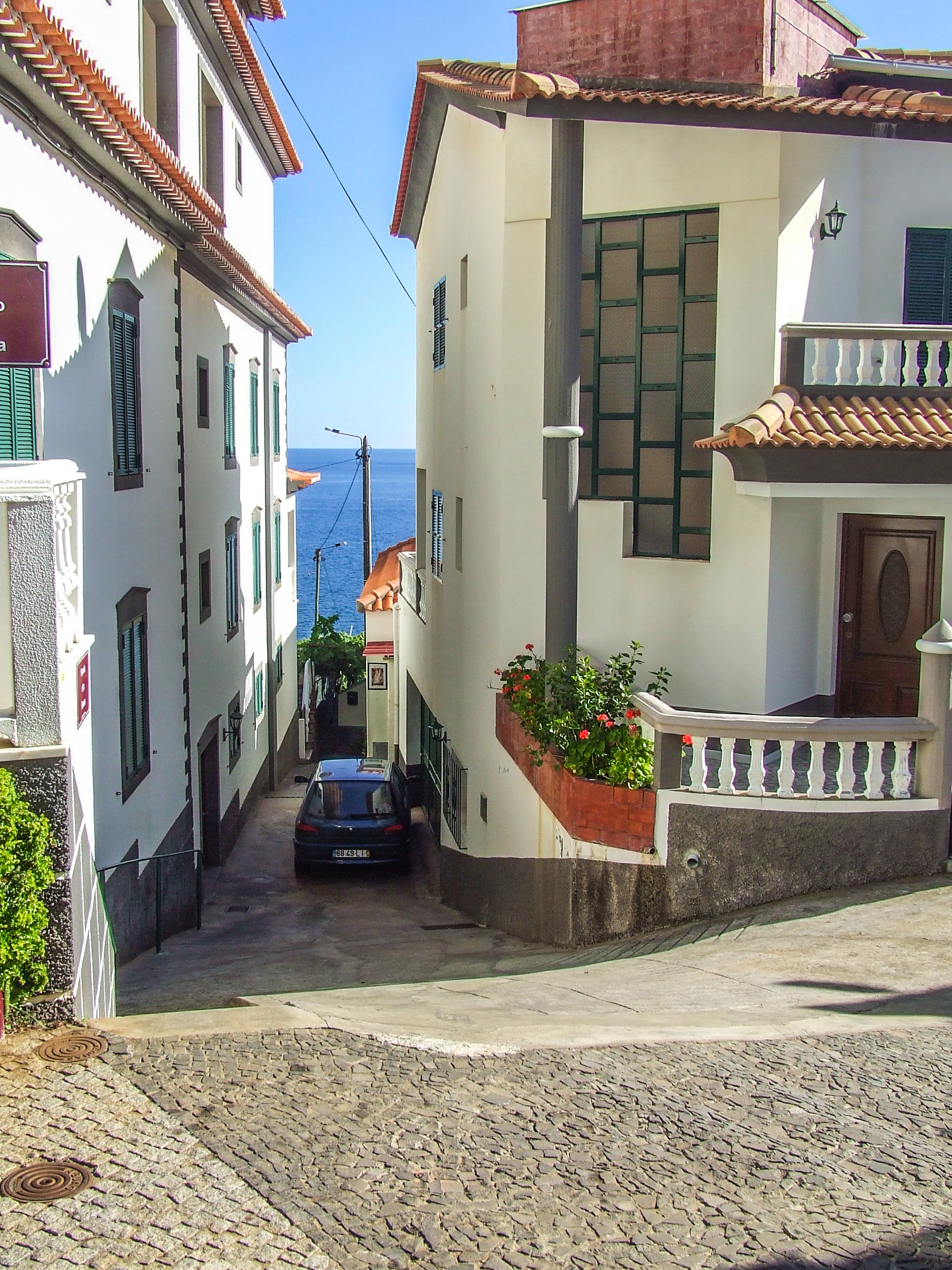 a narrow, cobblestone street in a coastal town