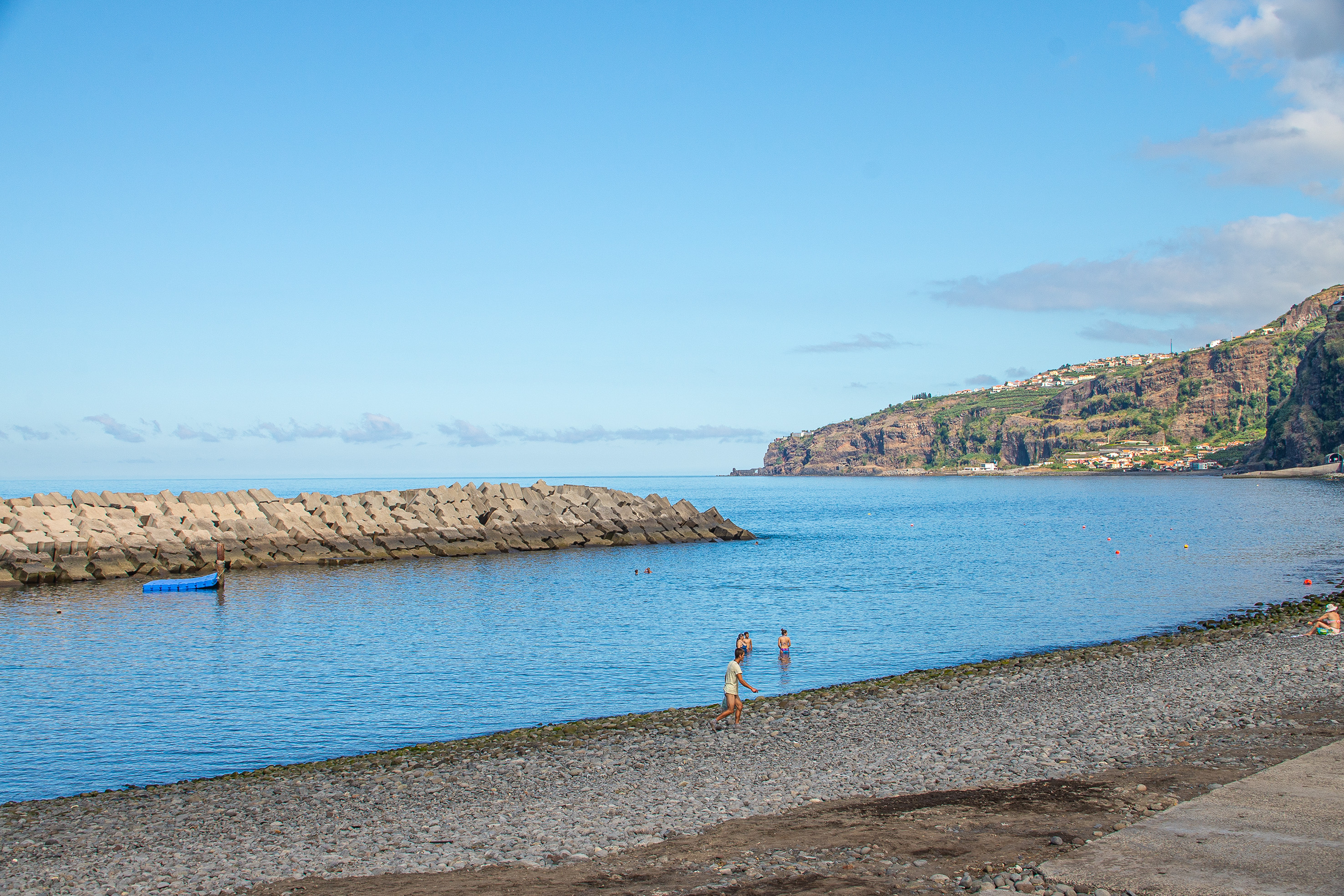 a breakwater extending into the calm blue sea