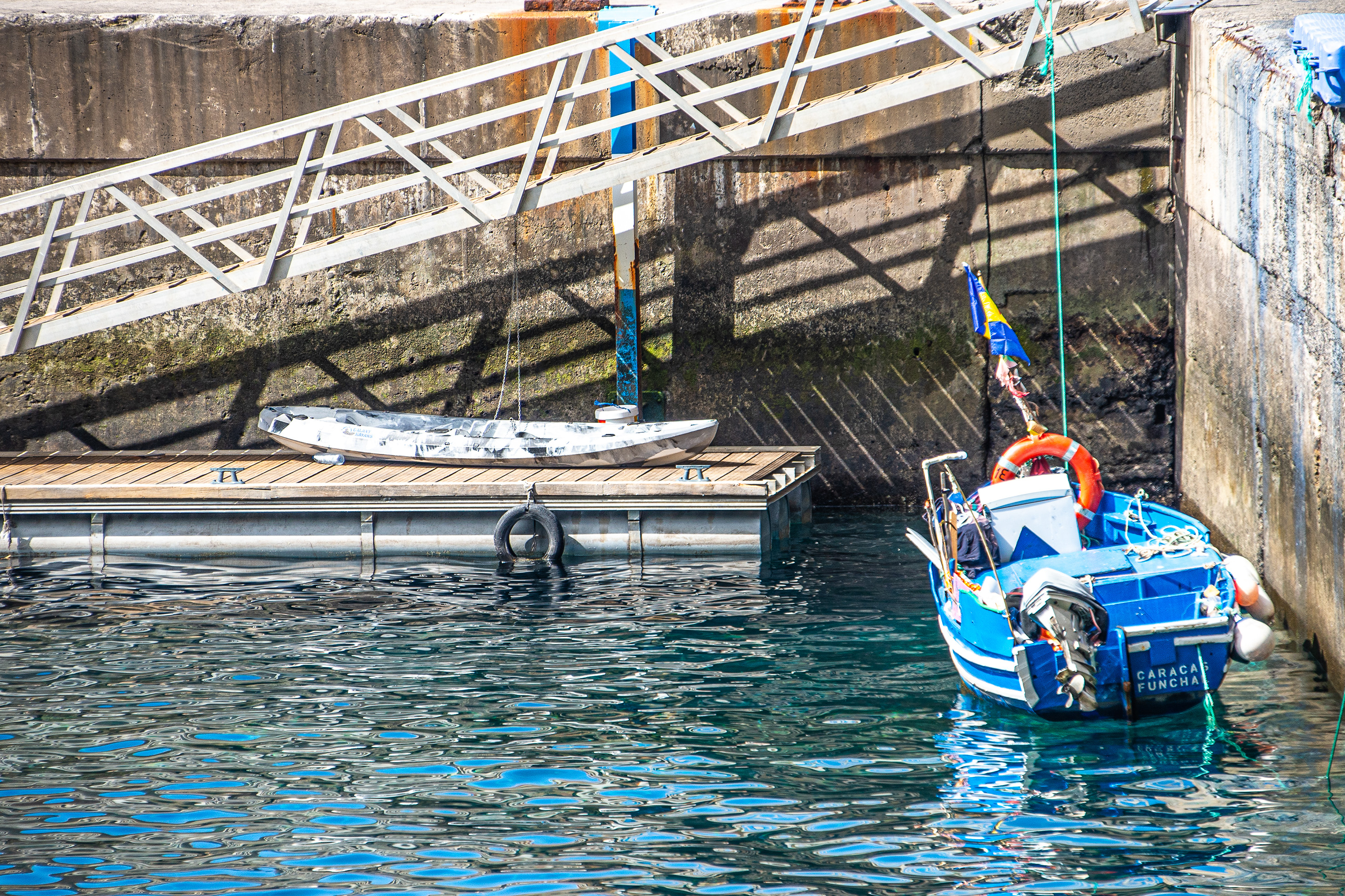 a blue and white boat named 'CARACA FUNCHAL'