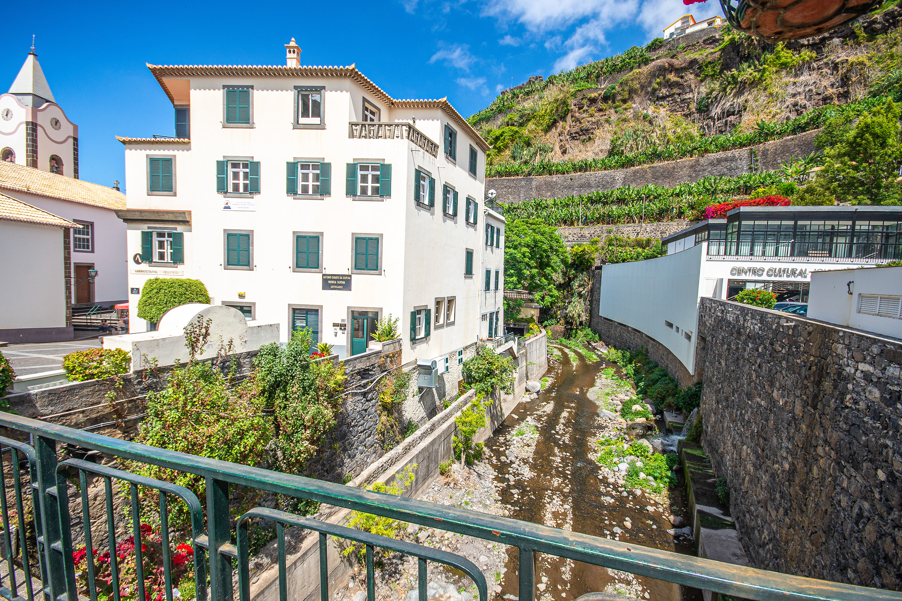 white buildings featuring green shutters and tiled roofs