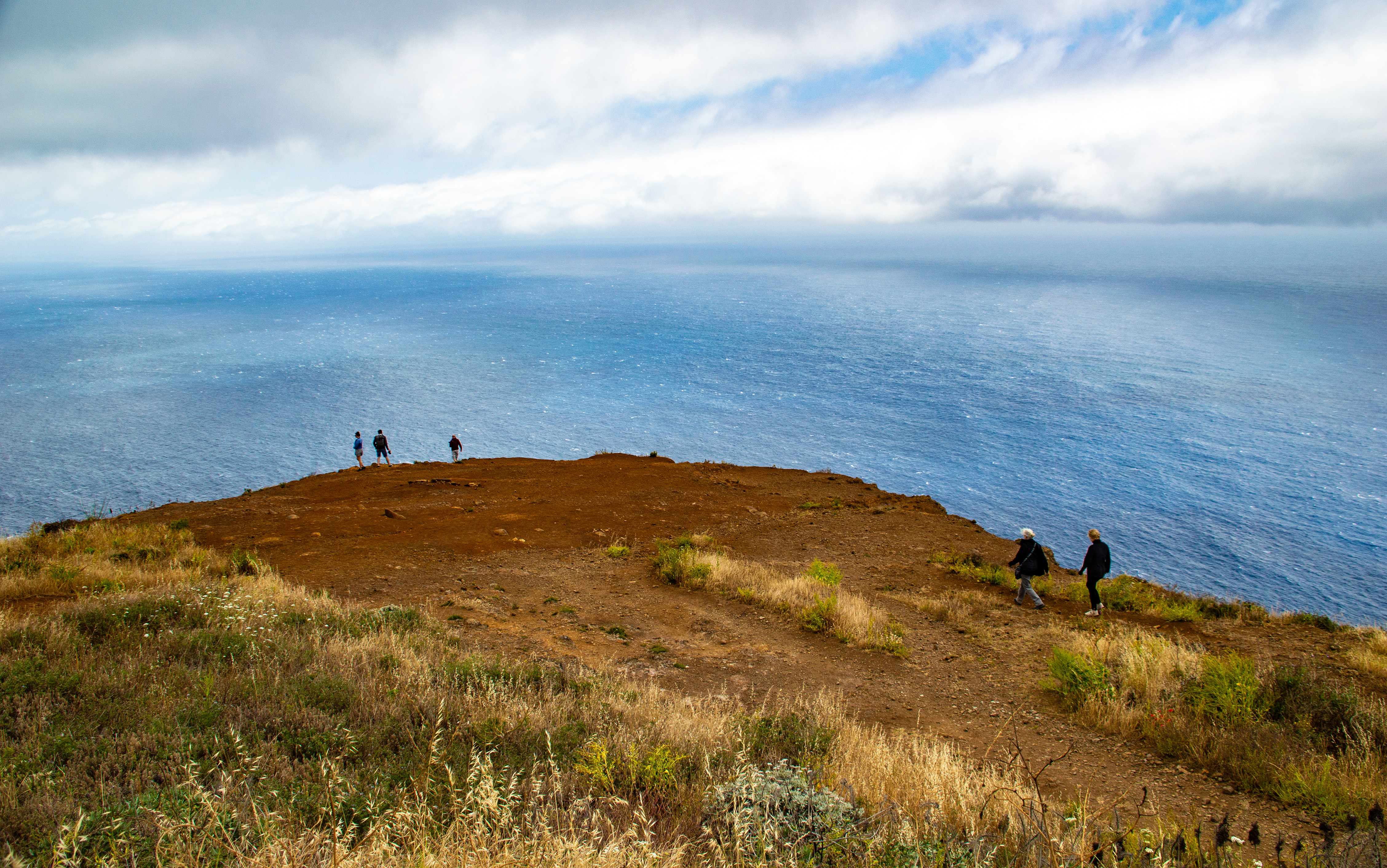 group of people hiking along a cliff