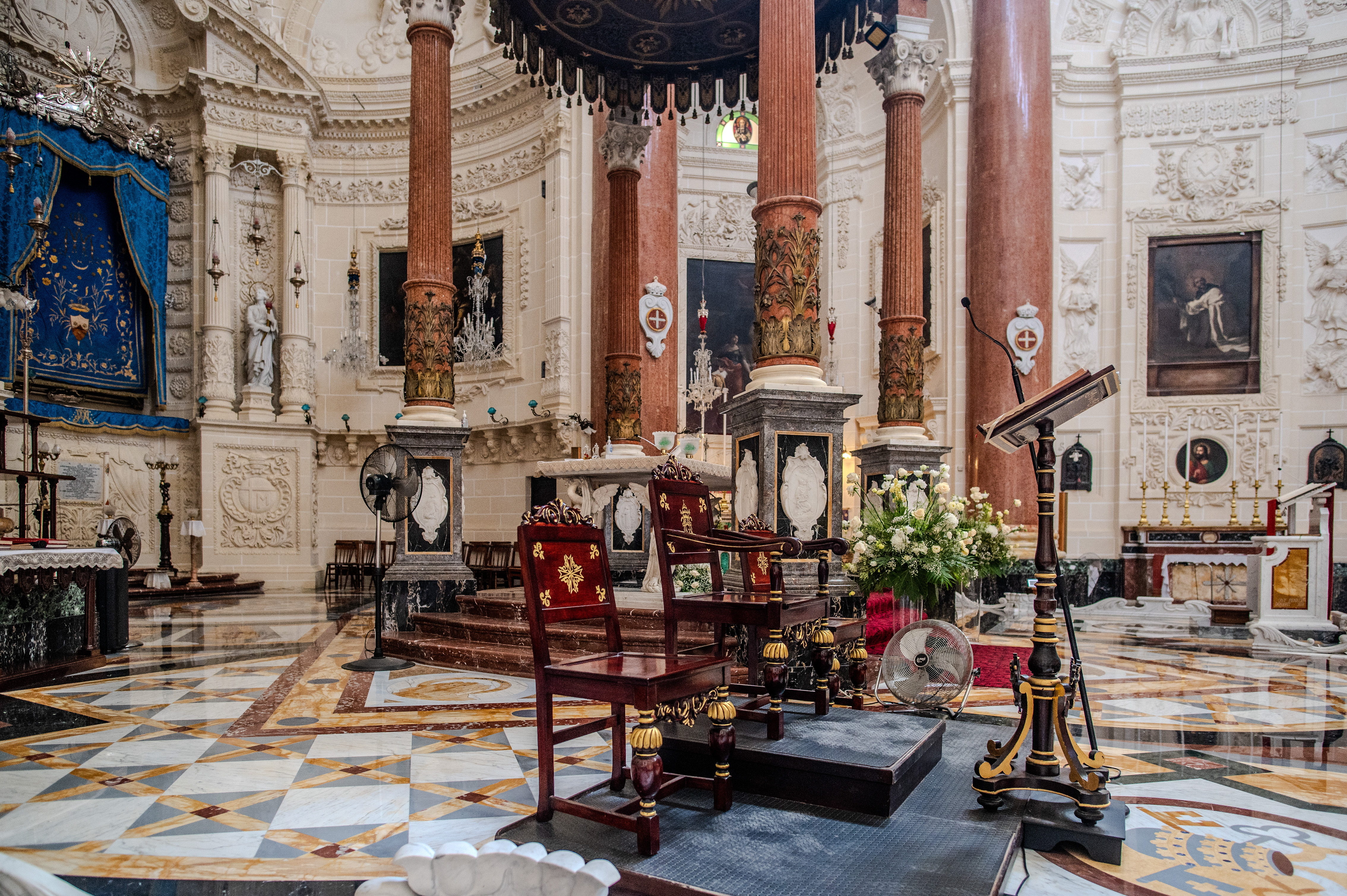 a wooden altar with a lectern, surrounded by marble and stone structures