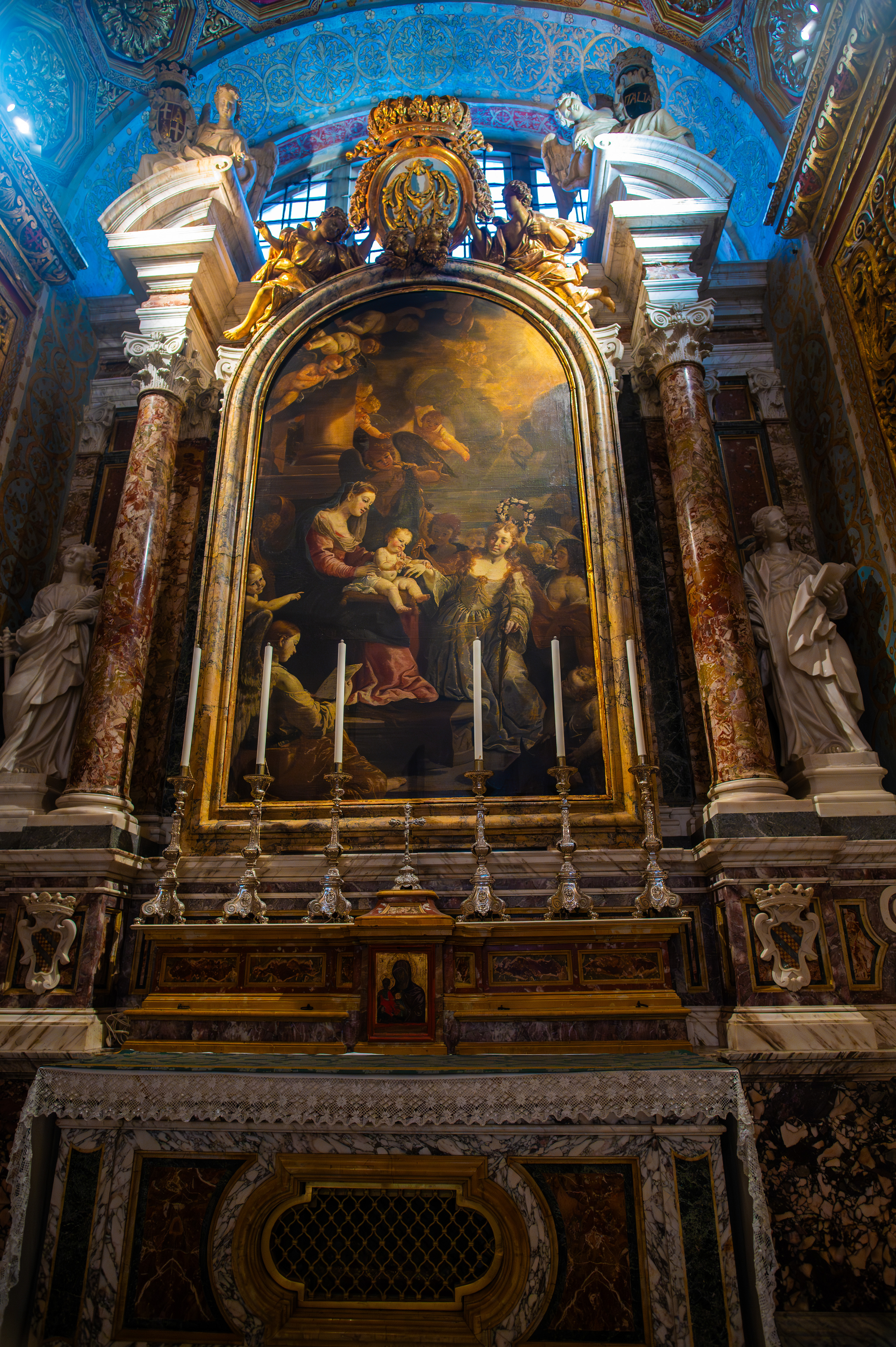 The central painting shows a religious scene with several figures, including a central female figure holding a child