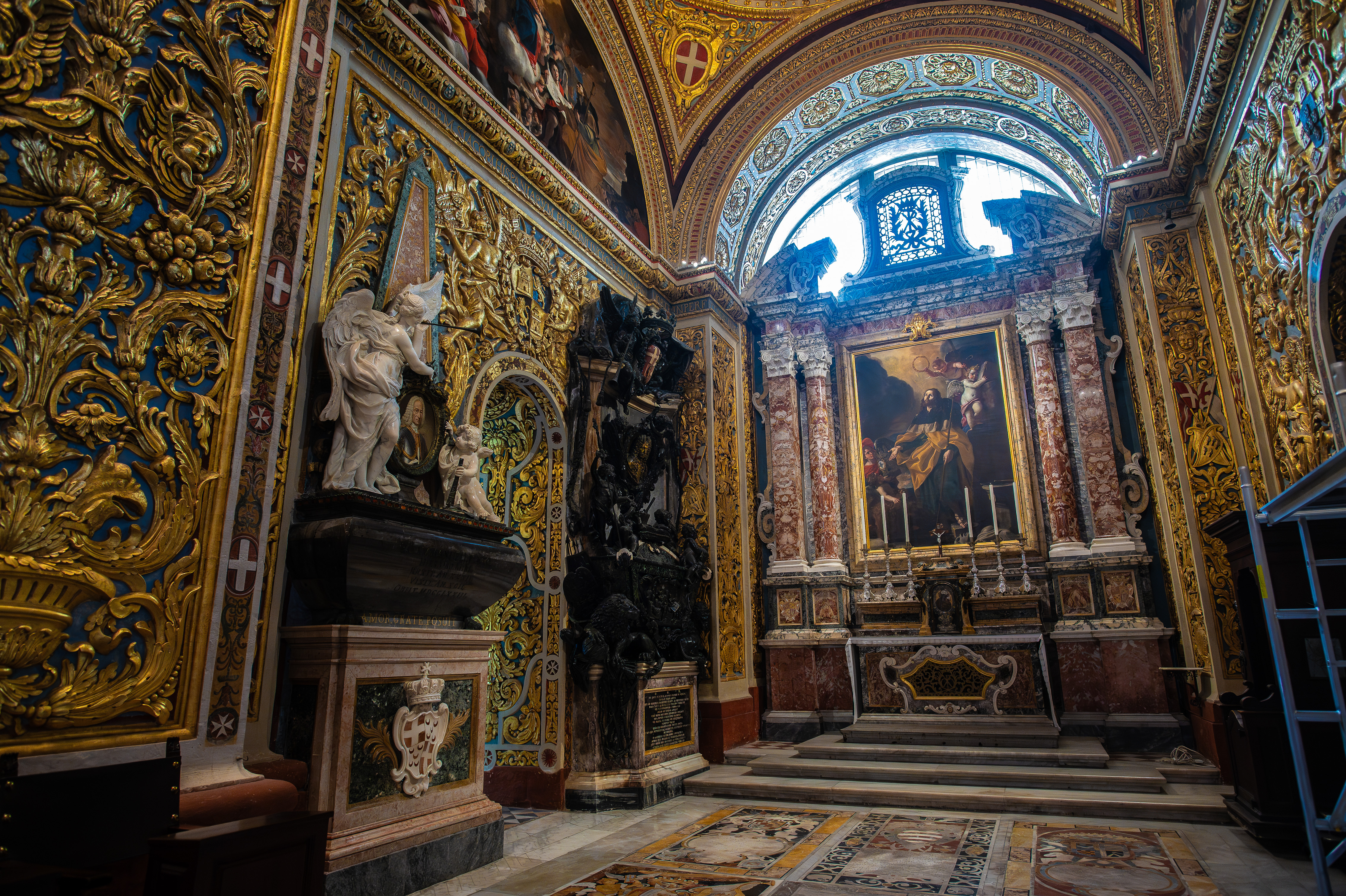 The walls and ceiling are adorned with intricate gold patterns, frescoes, and statues
