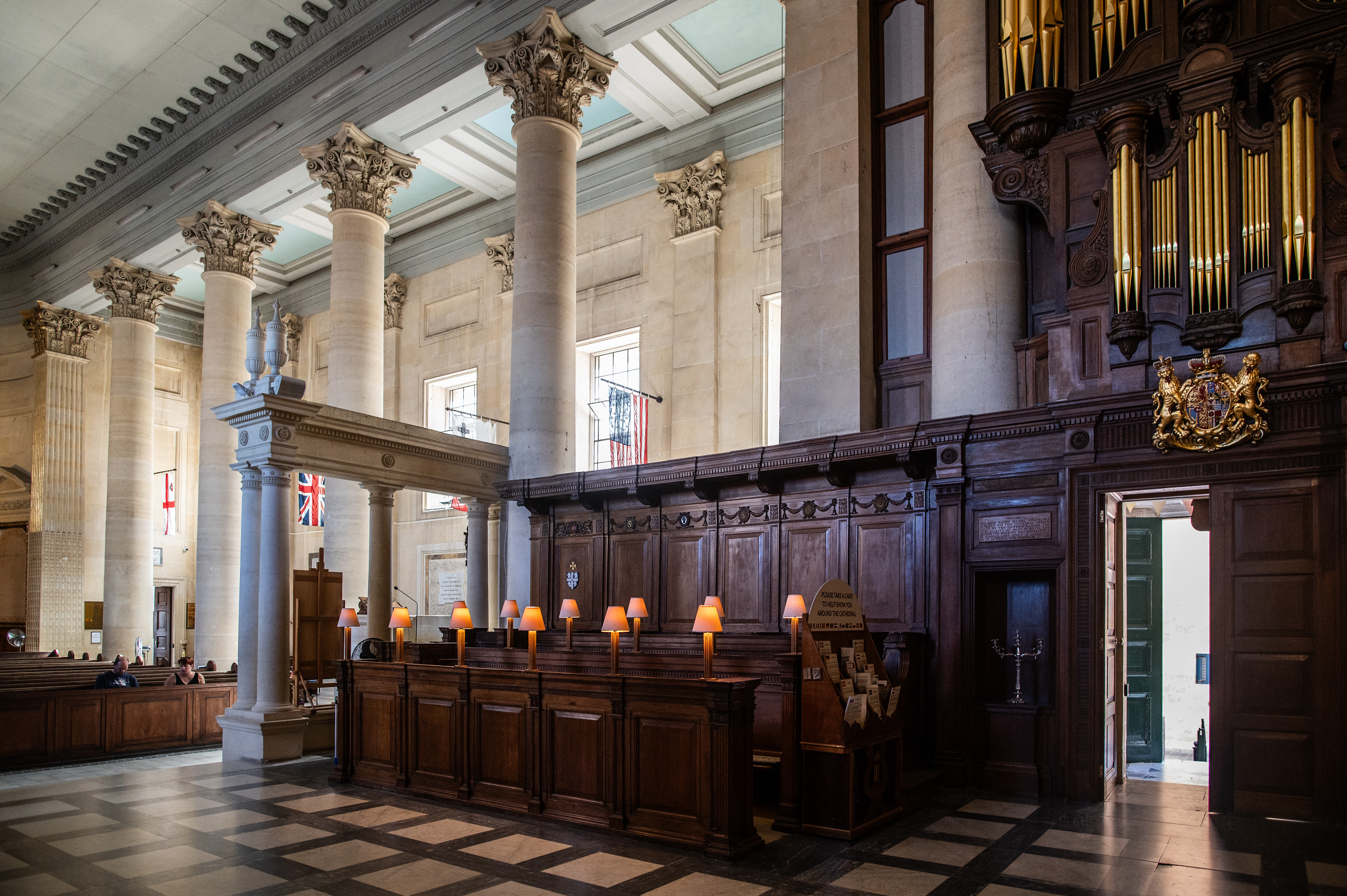 pulpit area with multiple lit candles and a coat of arms above it