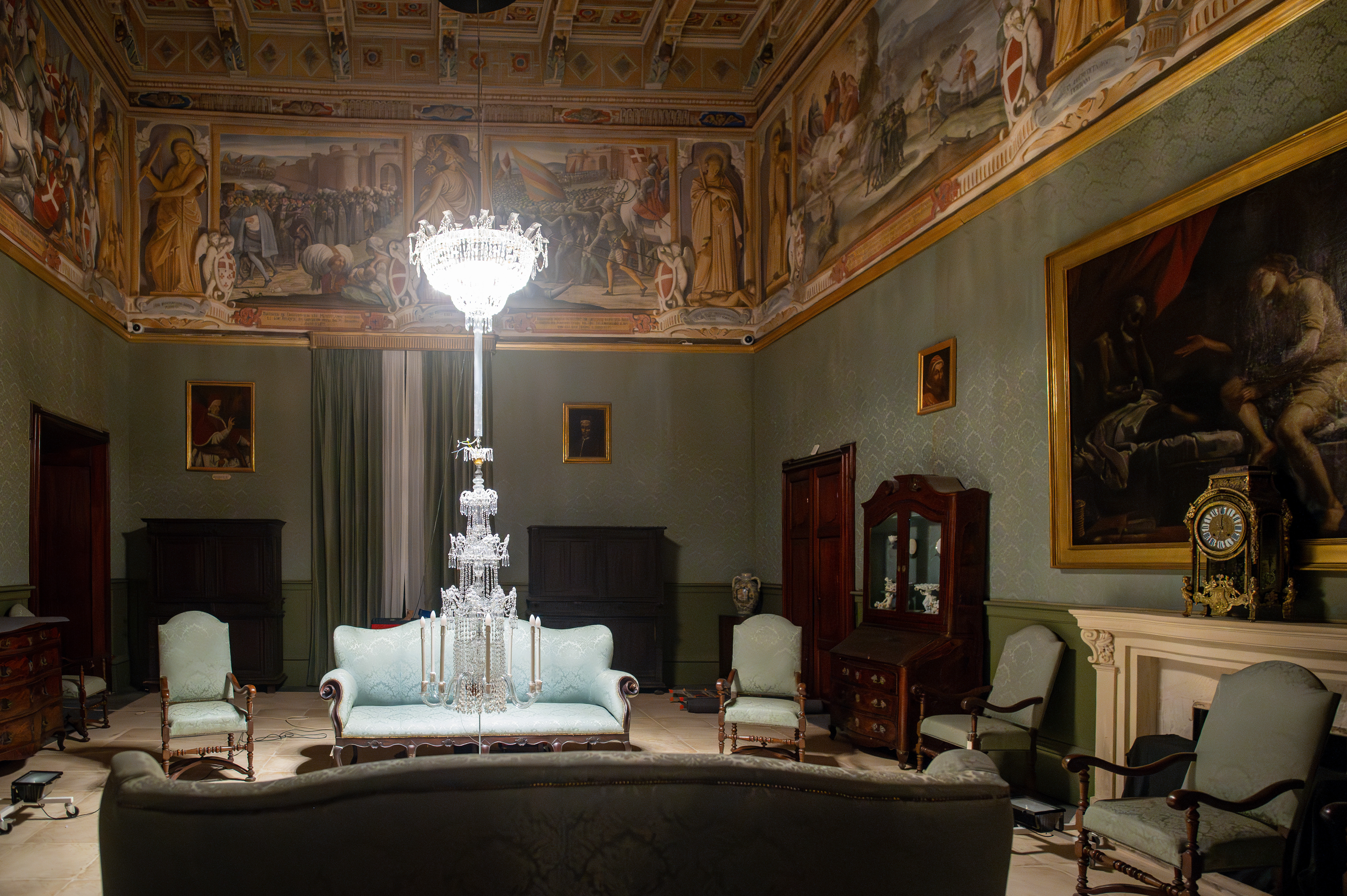 an opulently decorated room with richly adorned furniture and intricate ceiling frescoes