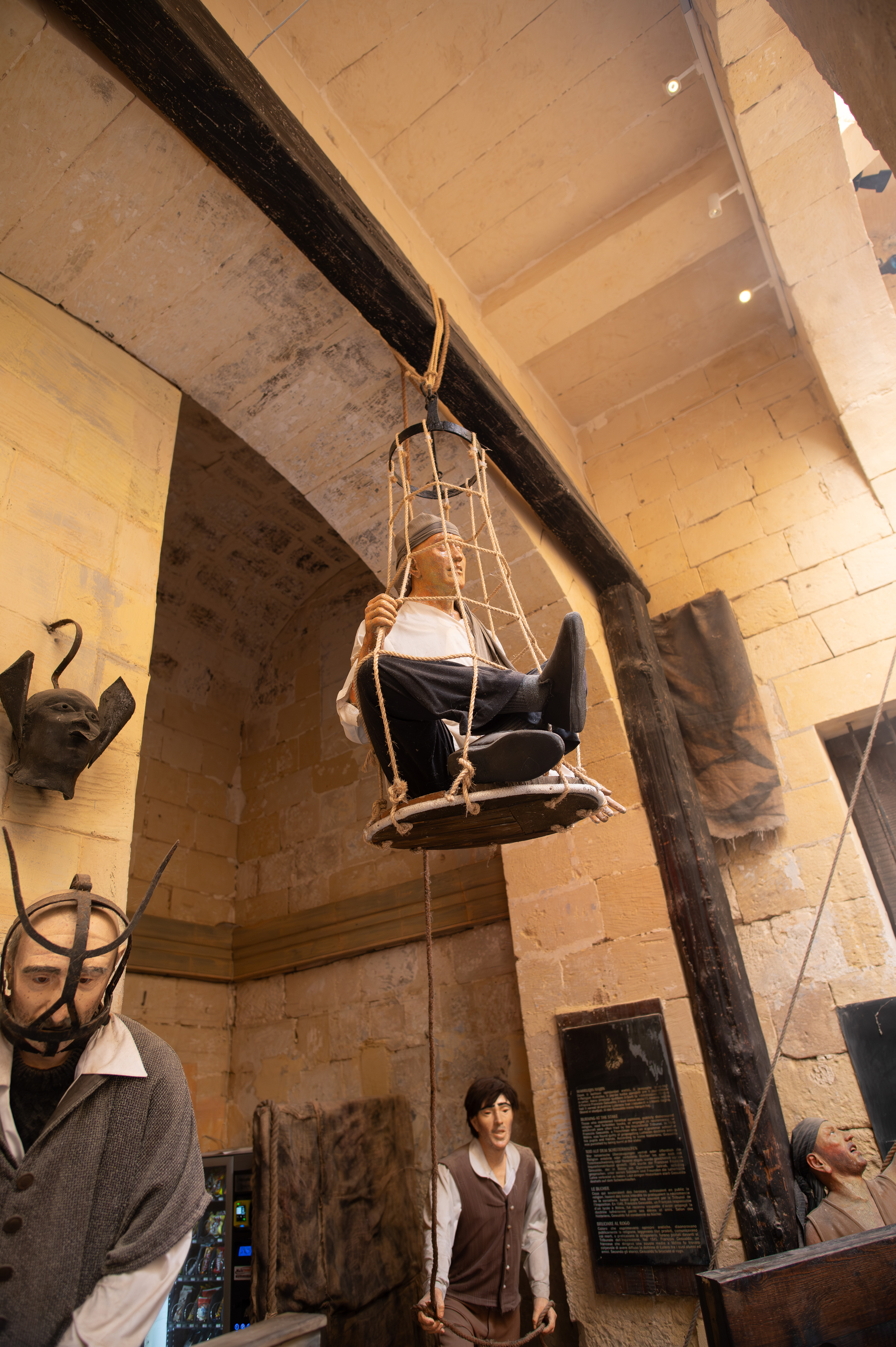 A mannequin is suspended in a cage-like structure