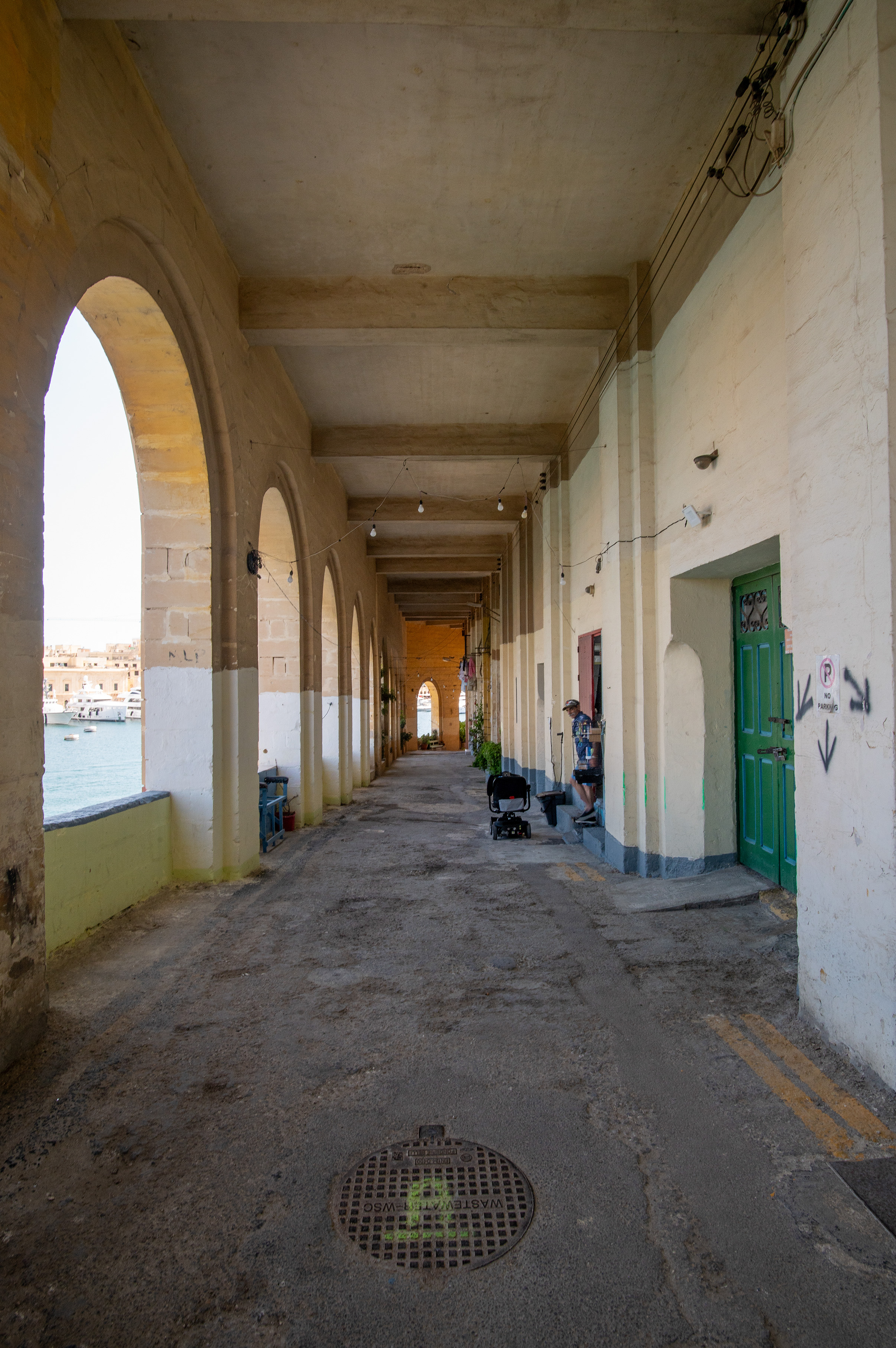 The image depicts a corridor with a series of arches on the left side