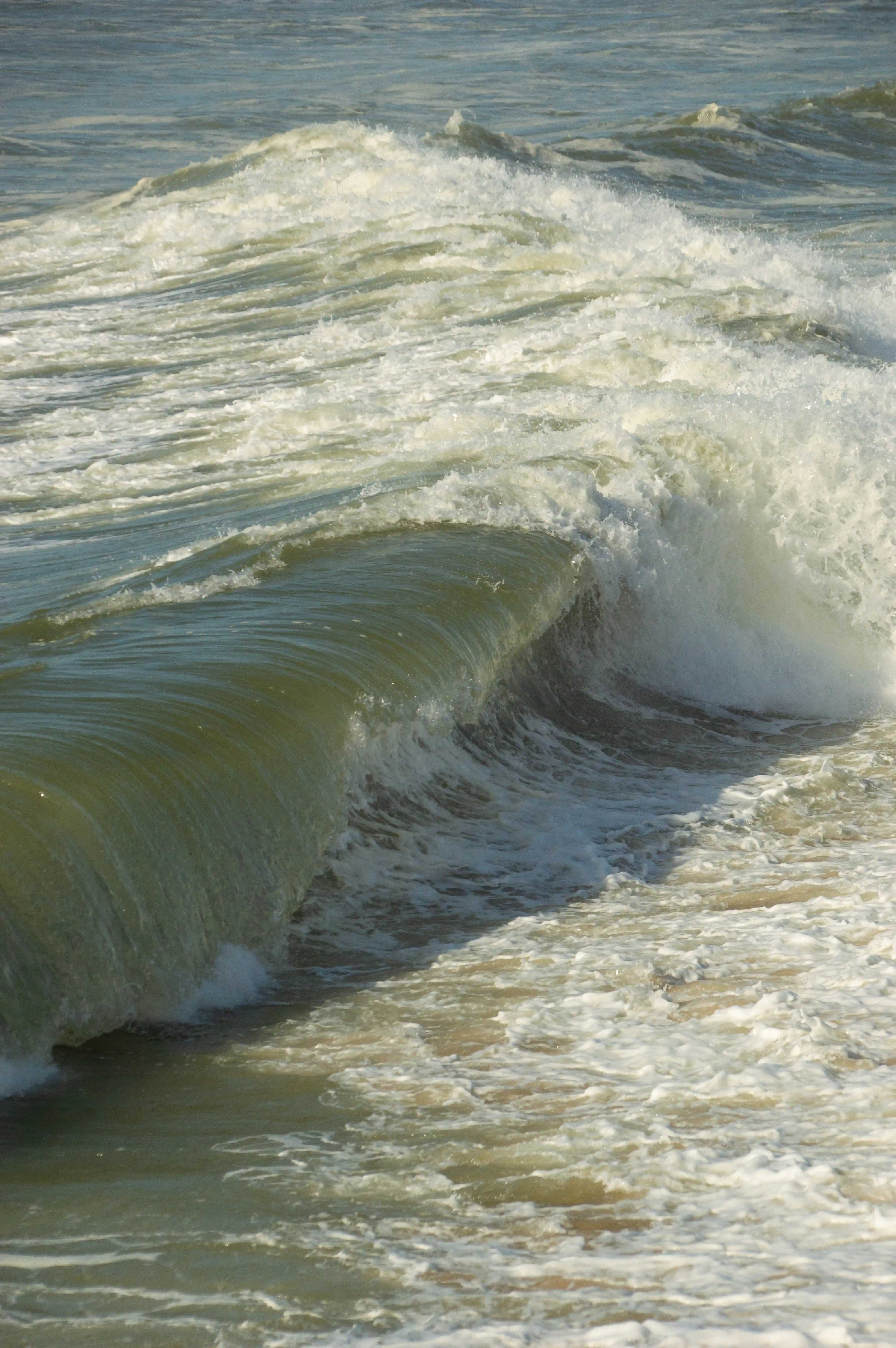 A breaking ocean wave with turquoise water and white foam.