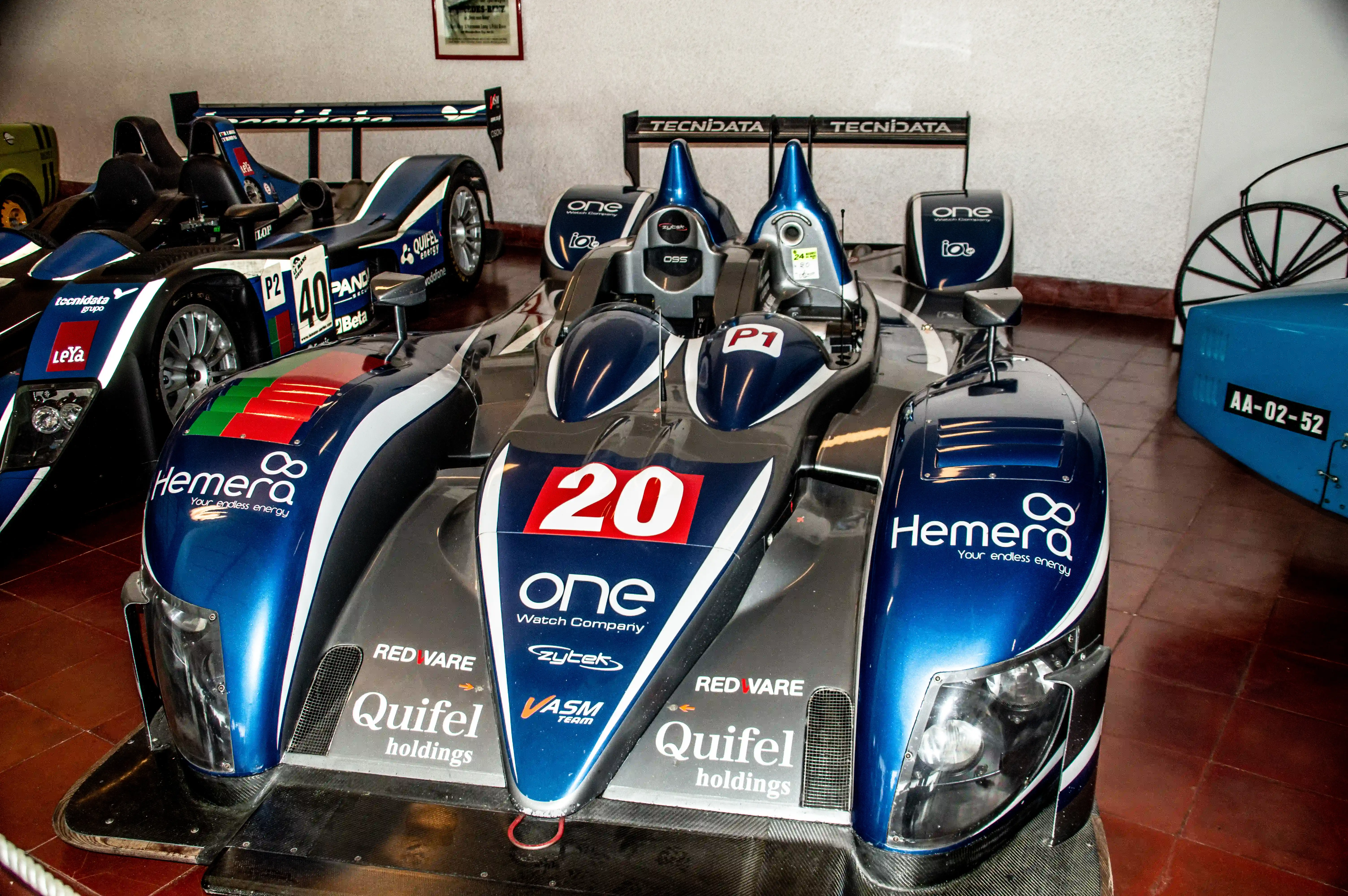 Two blue and grey racing cars with prominent sponsor logos such as 