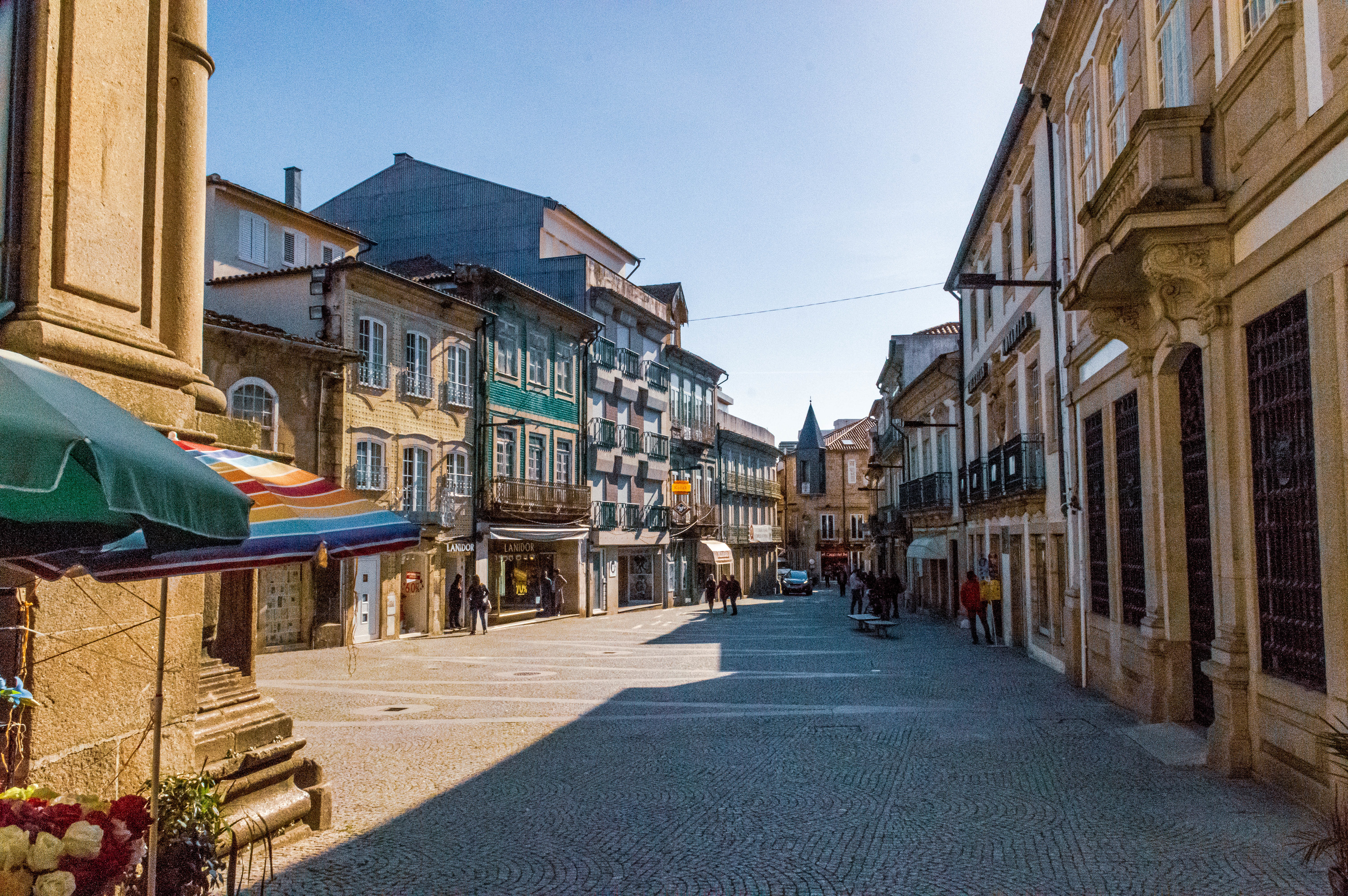  The street is lined with old, multi-story buildings featuring a mix of architectural styles