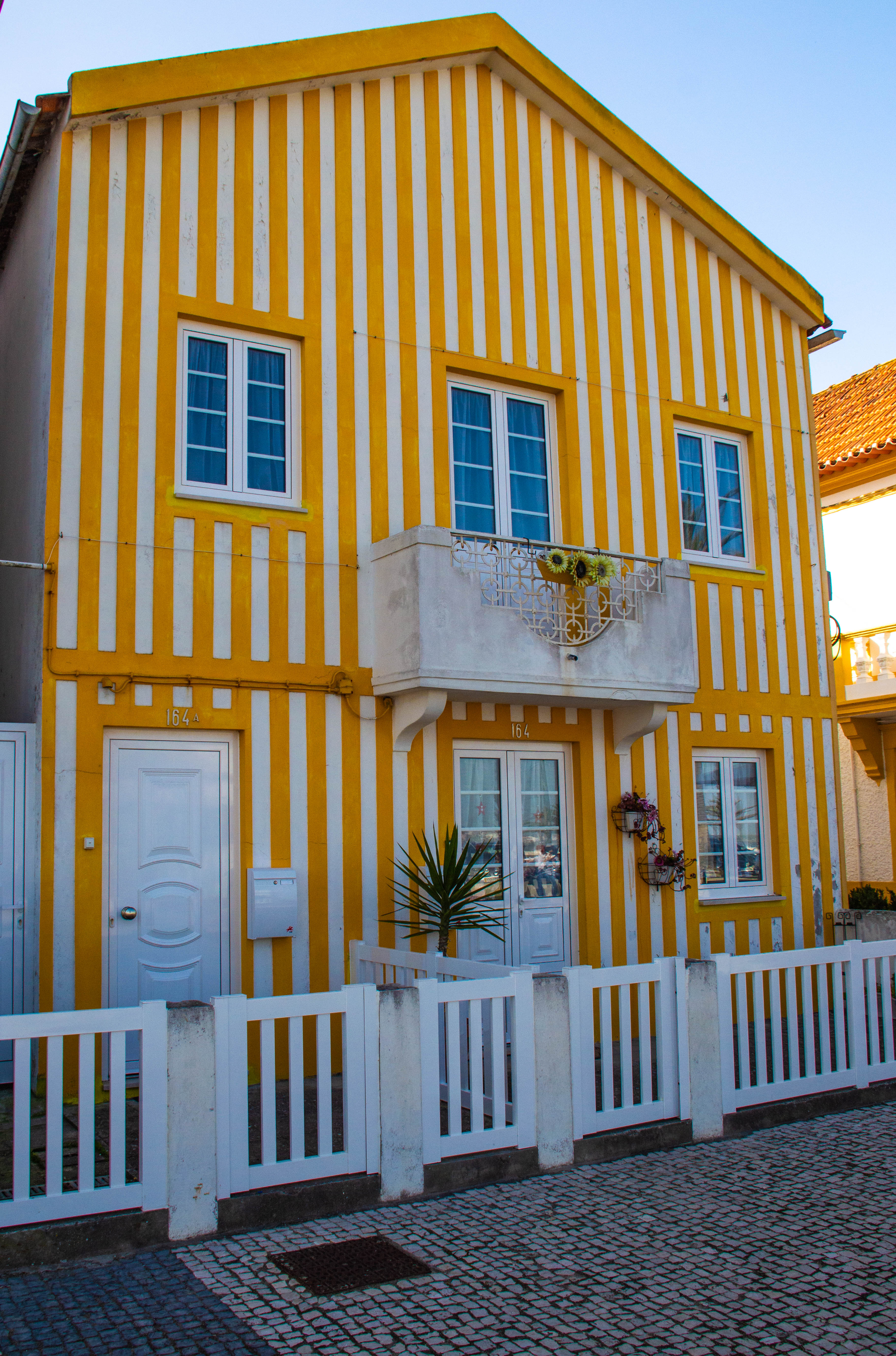 a charming, two-story house with a distinctive yellow and white striped exterior